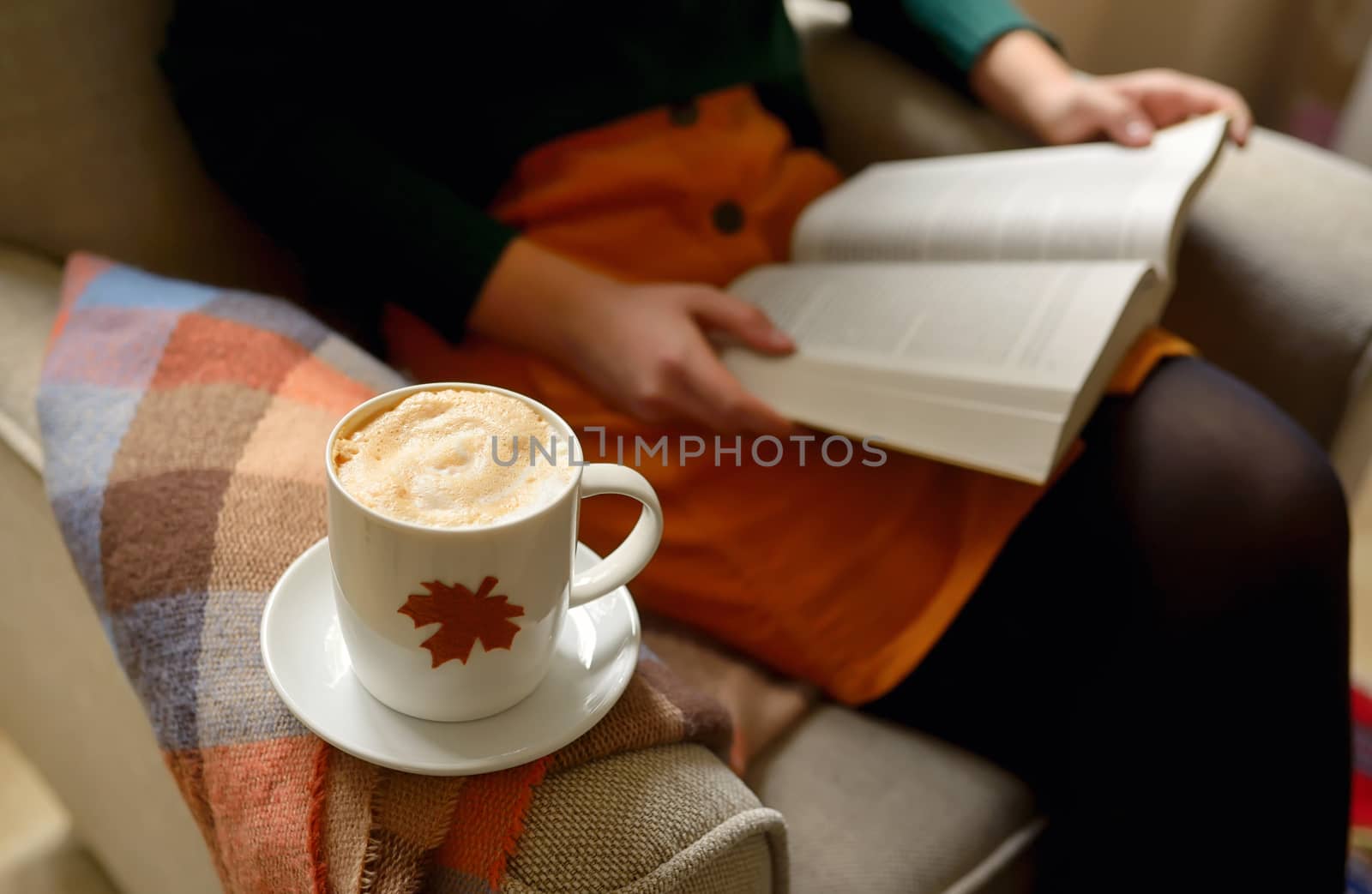 Cup of cappuccino coffee and girl reading a book 