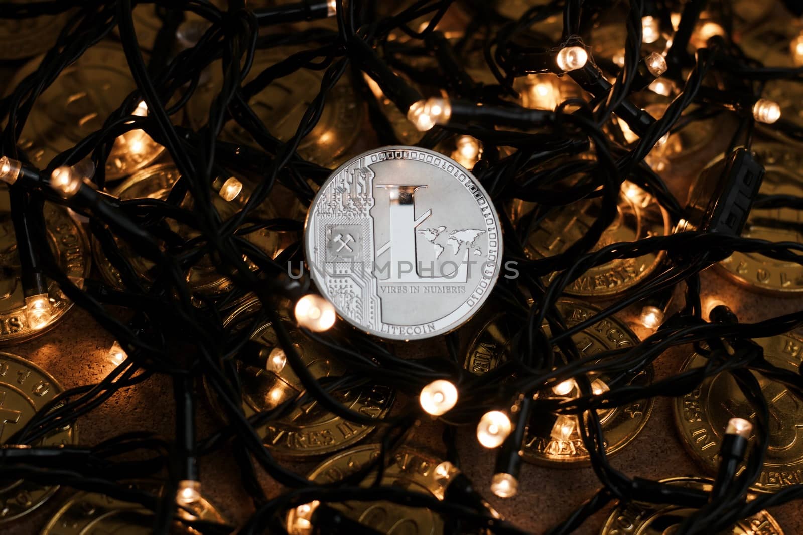 Digital currency physical metal Litecoin coin on the christmas lights concept.