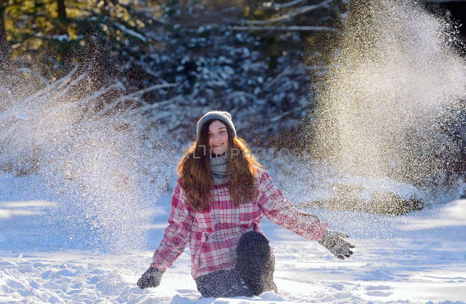 teen girl playing in snow in winter time