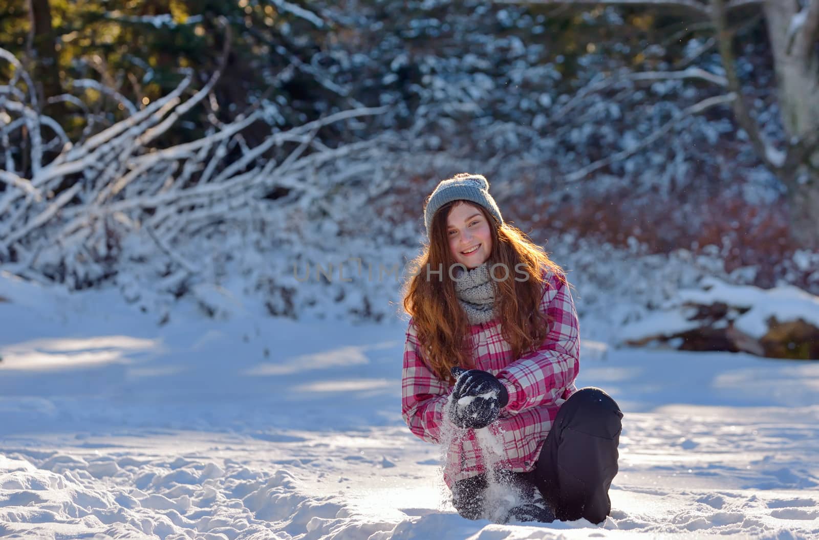 teen girl playing in snow in winter time