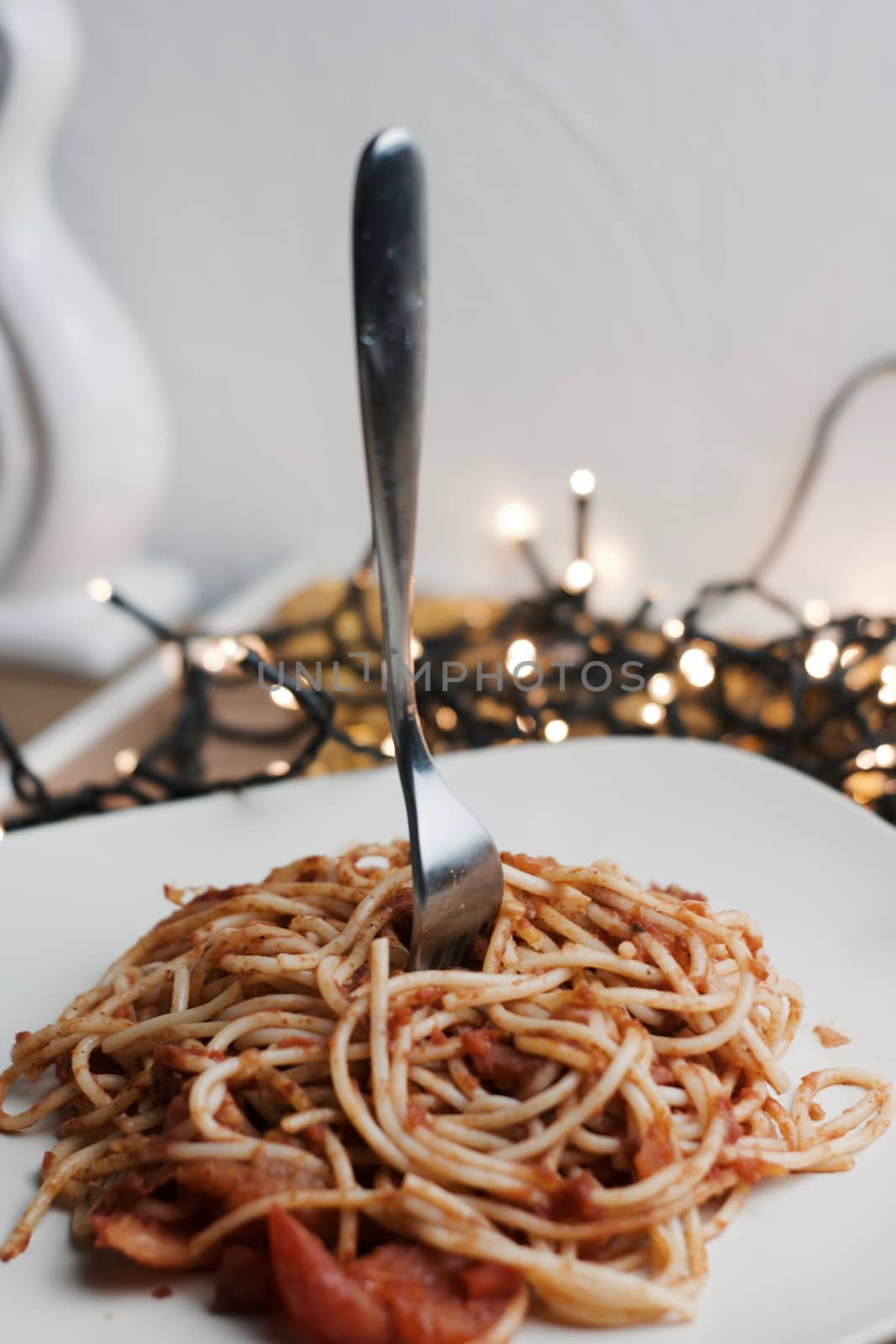Italian tasty pasta with tomatoes on a fork. Christmas food concept.