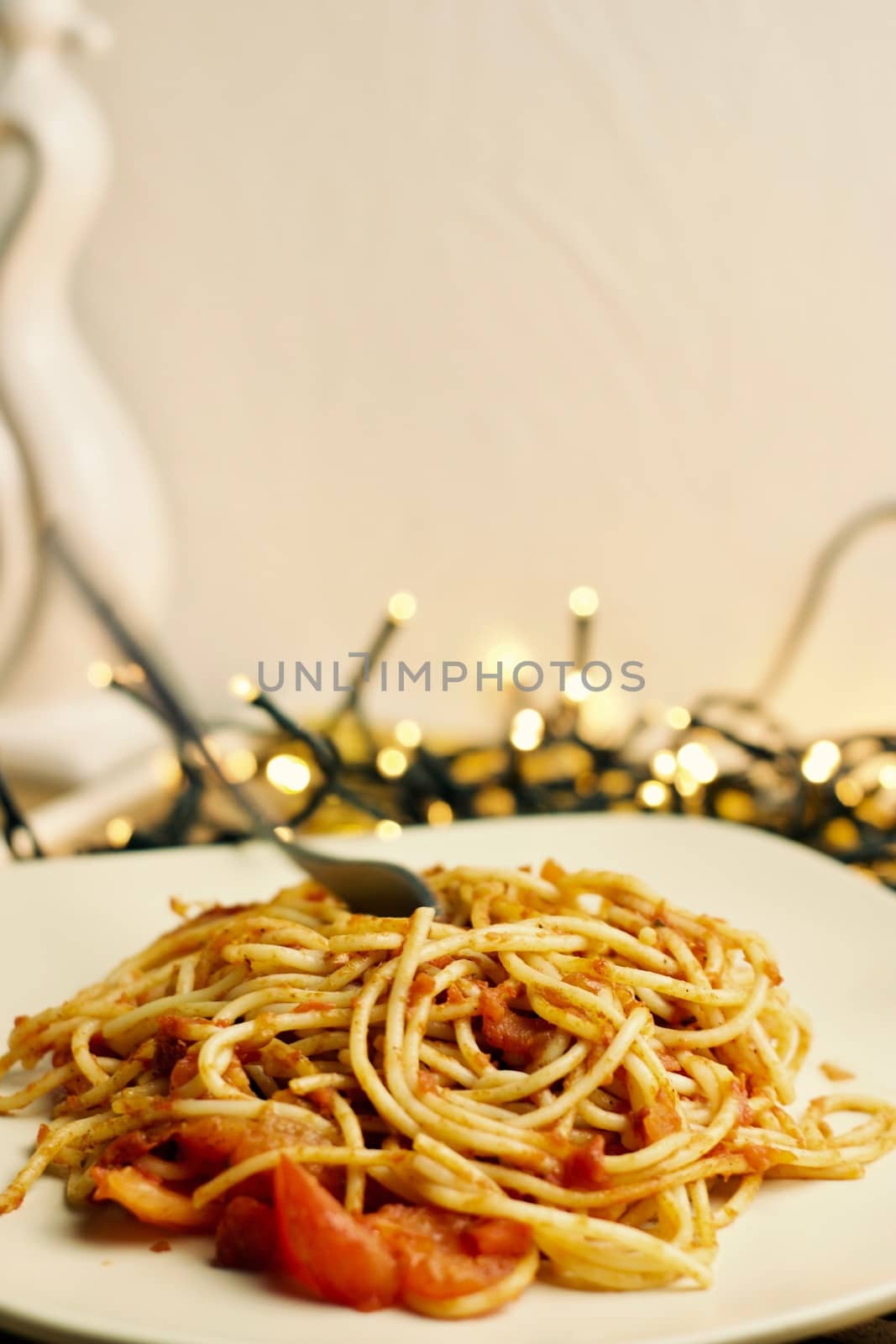 Italian tasty pasta with tomatoes on a fork. Christmas food concept.