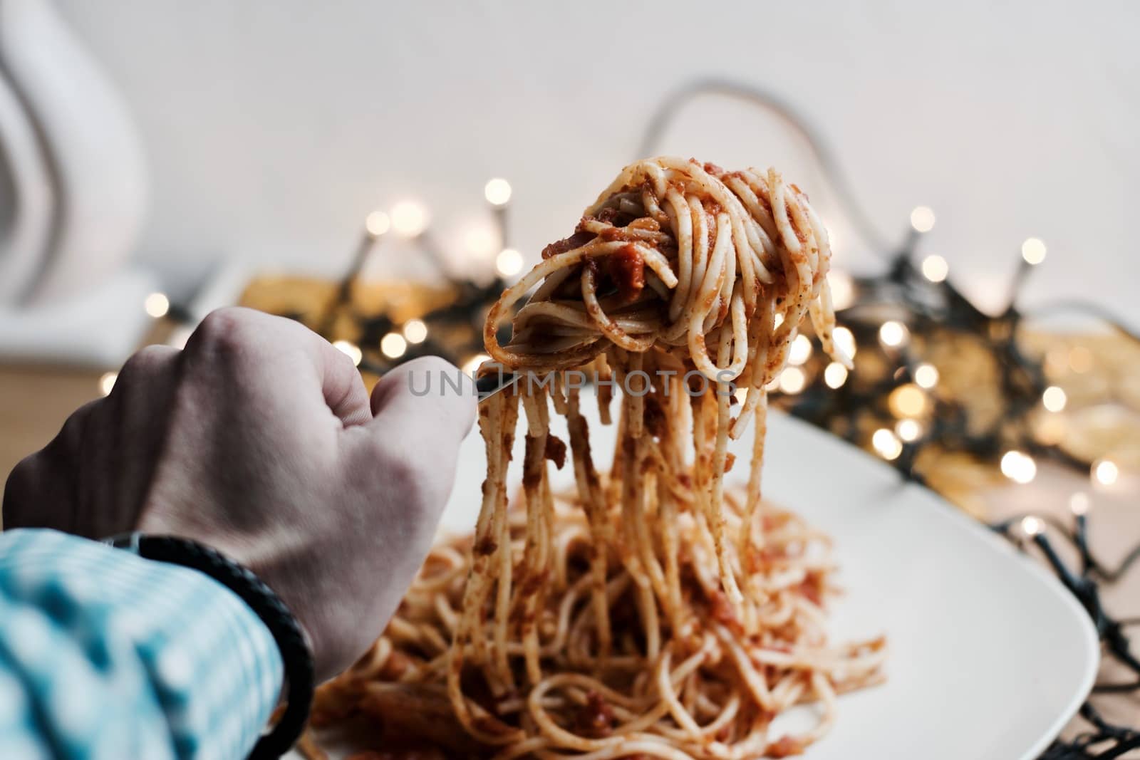 Italian tasty pasta with tomatoes on a fork. Christmas food concept.