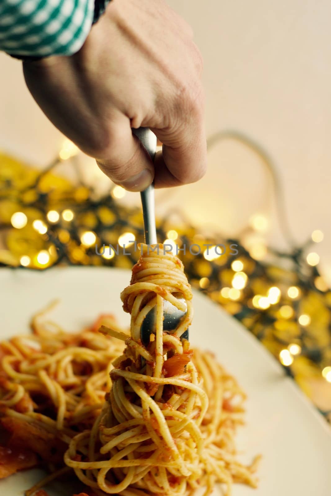 Italian tasty pasta with tomatoes on a fork. Christmas food concept.