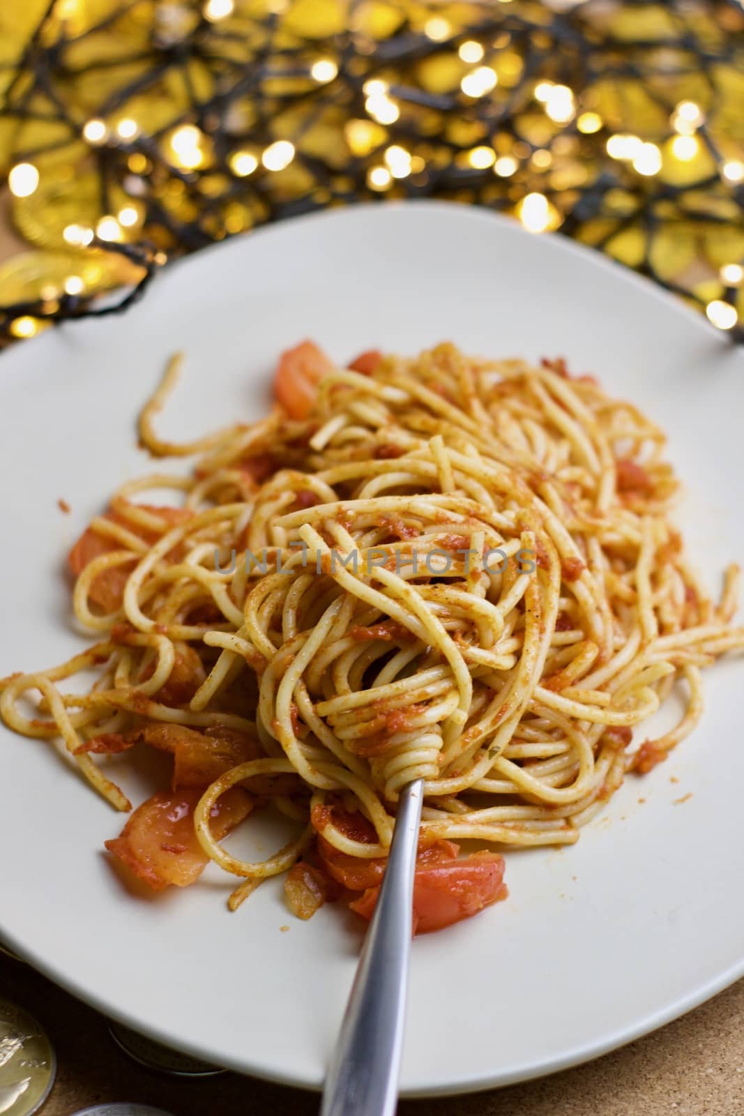 Italian tasty pasta with tomatoes on a fork. Christmas food concept.