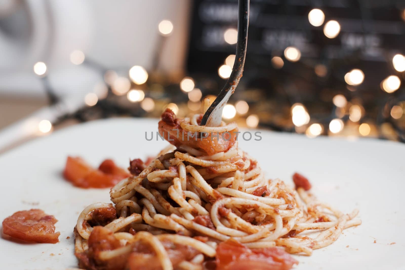 Italian tasty pasta with tomatoes on a silver fork. Christmas concept.