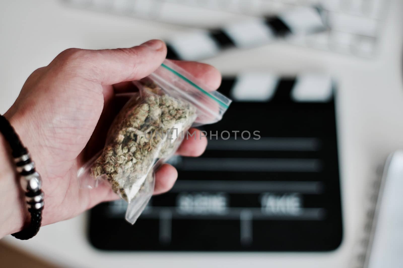 Green dry marijuana in man hand on the blurry background. Weed concept.