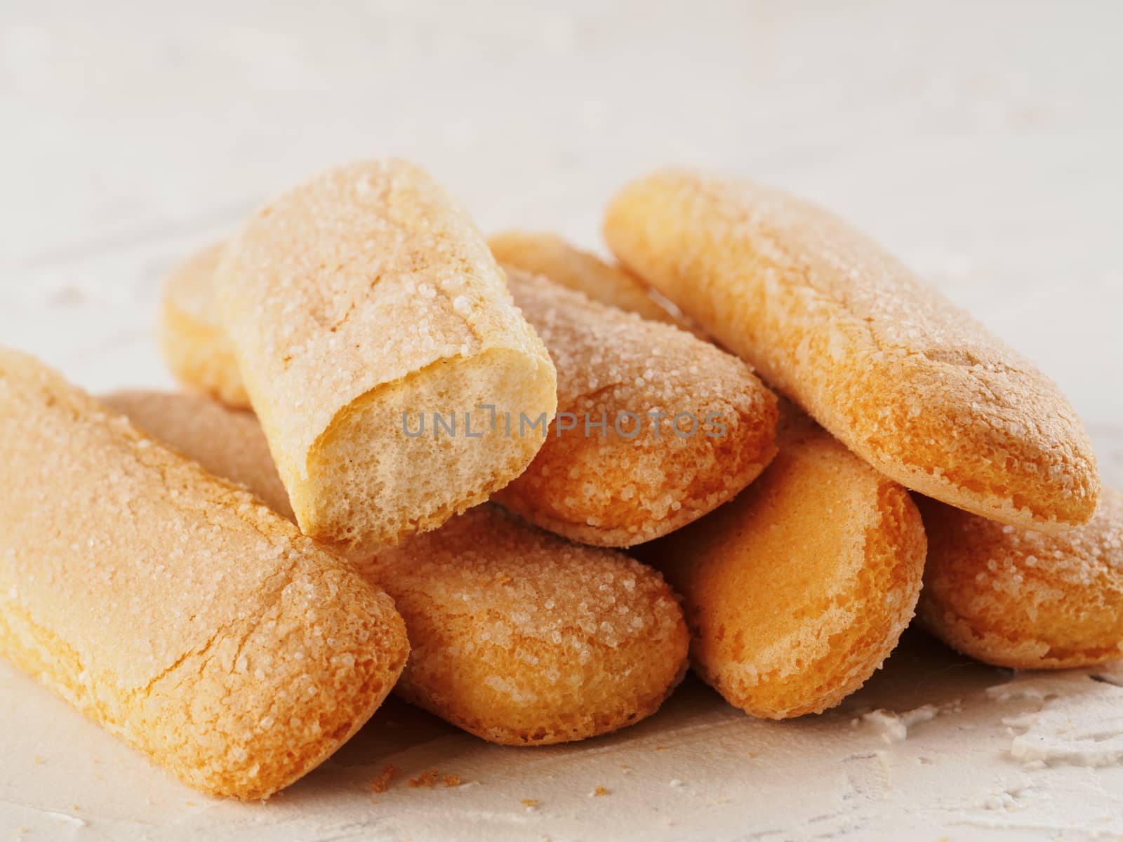 Close up view of ladyfinger biscuit cookie on white concrete background. Italian cookie savoiardi.