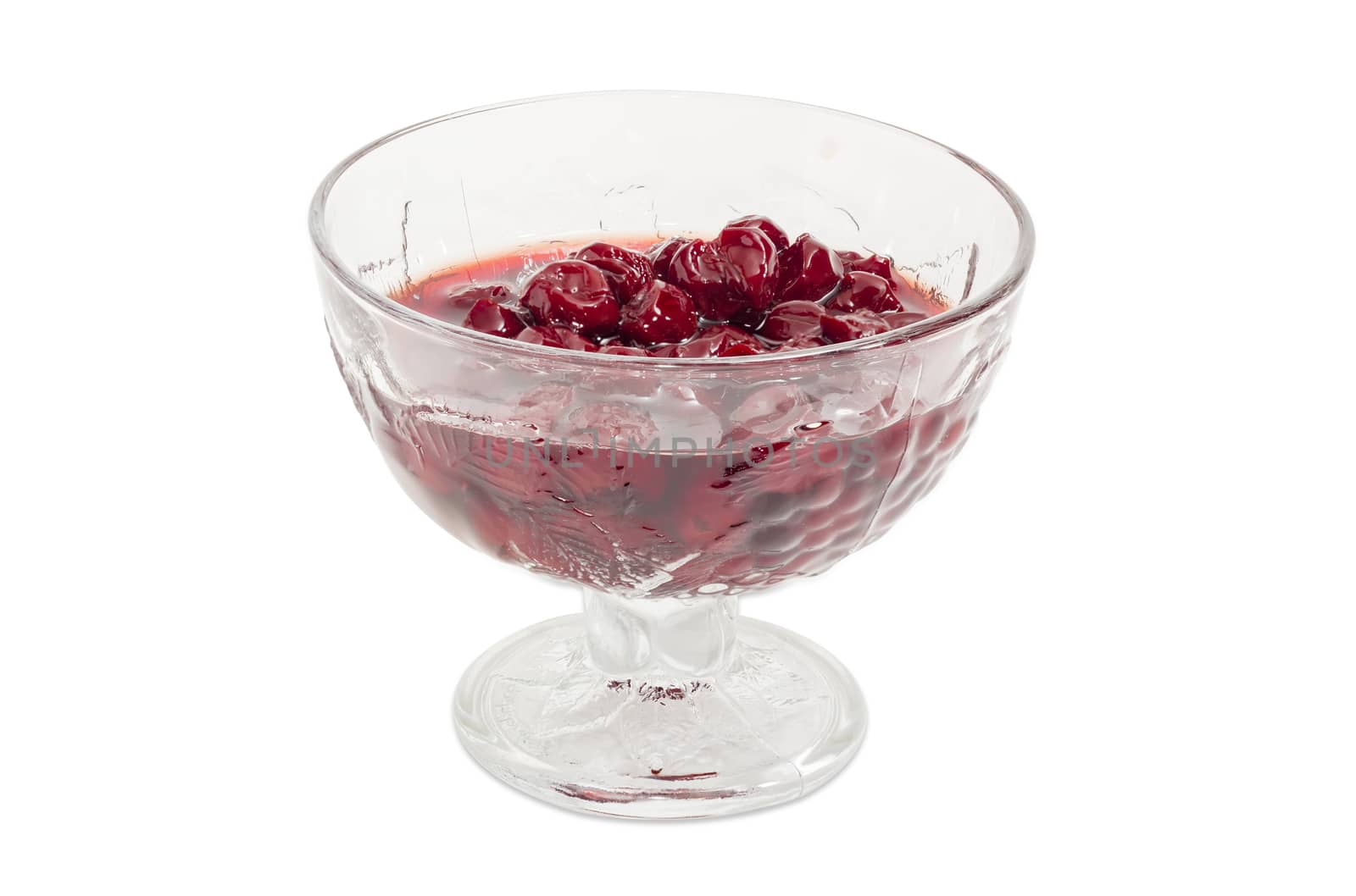 Cherry jam with whole fruits in the glass dessert stem bowl on a light background
