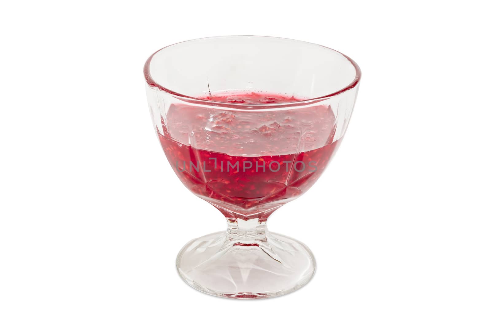 Raspberry jam in the glass dessert stem bowl on a light background
