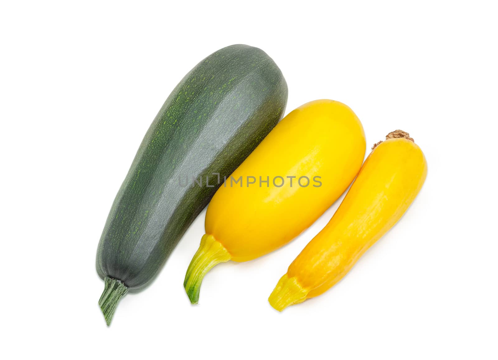 One fresh dark green zucchini and two yellow vegetable marrows on a light background
