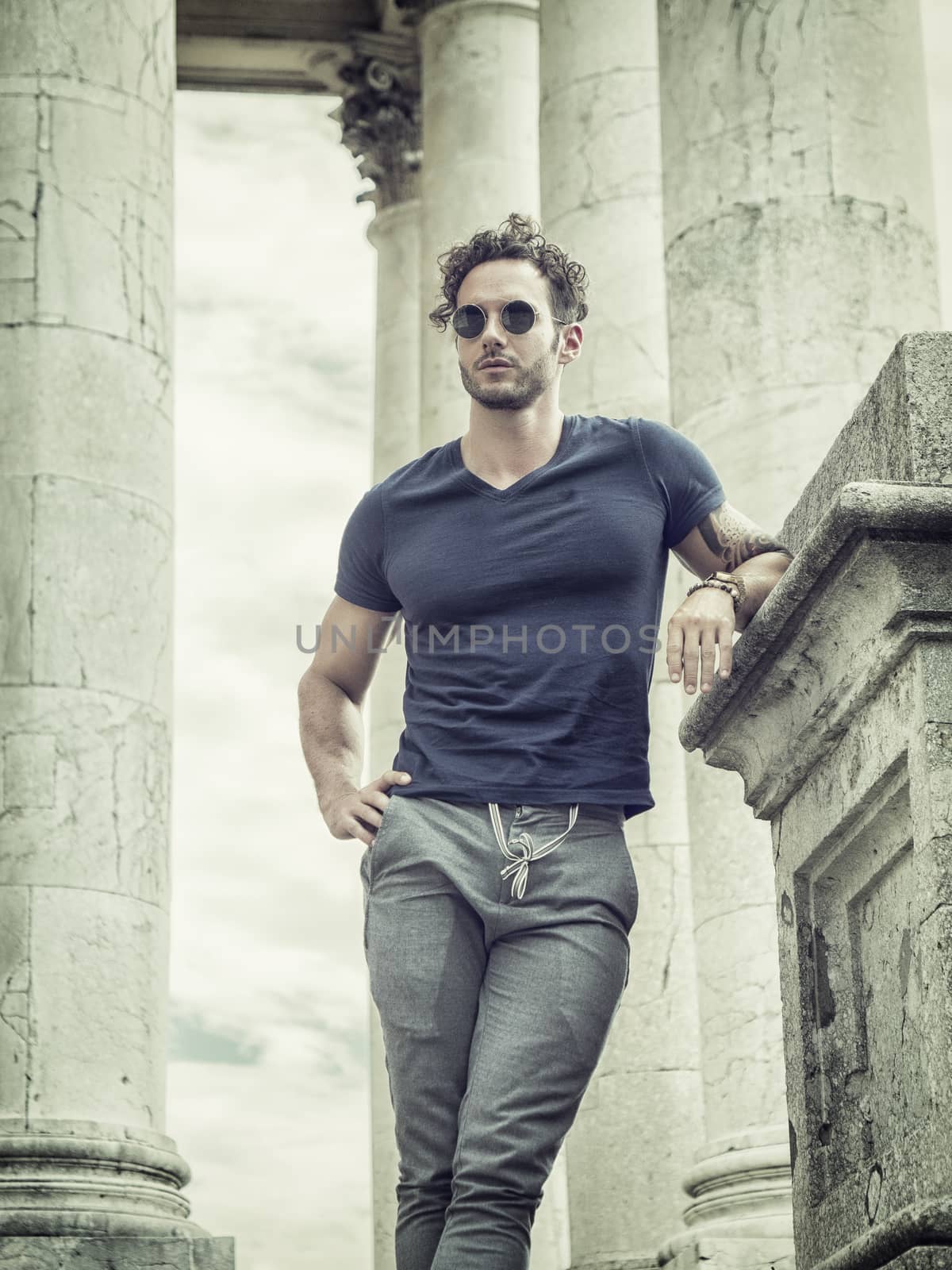 Handsome man outside under colonnade by artofphoto