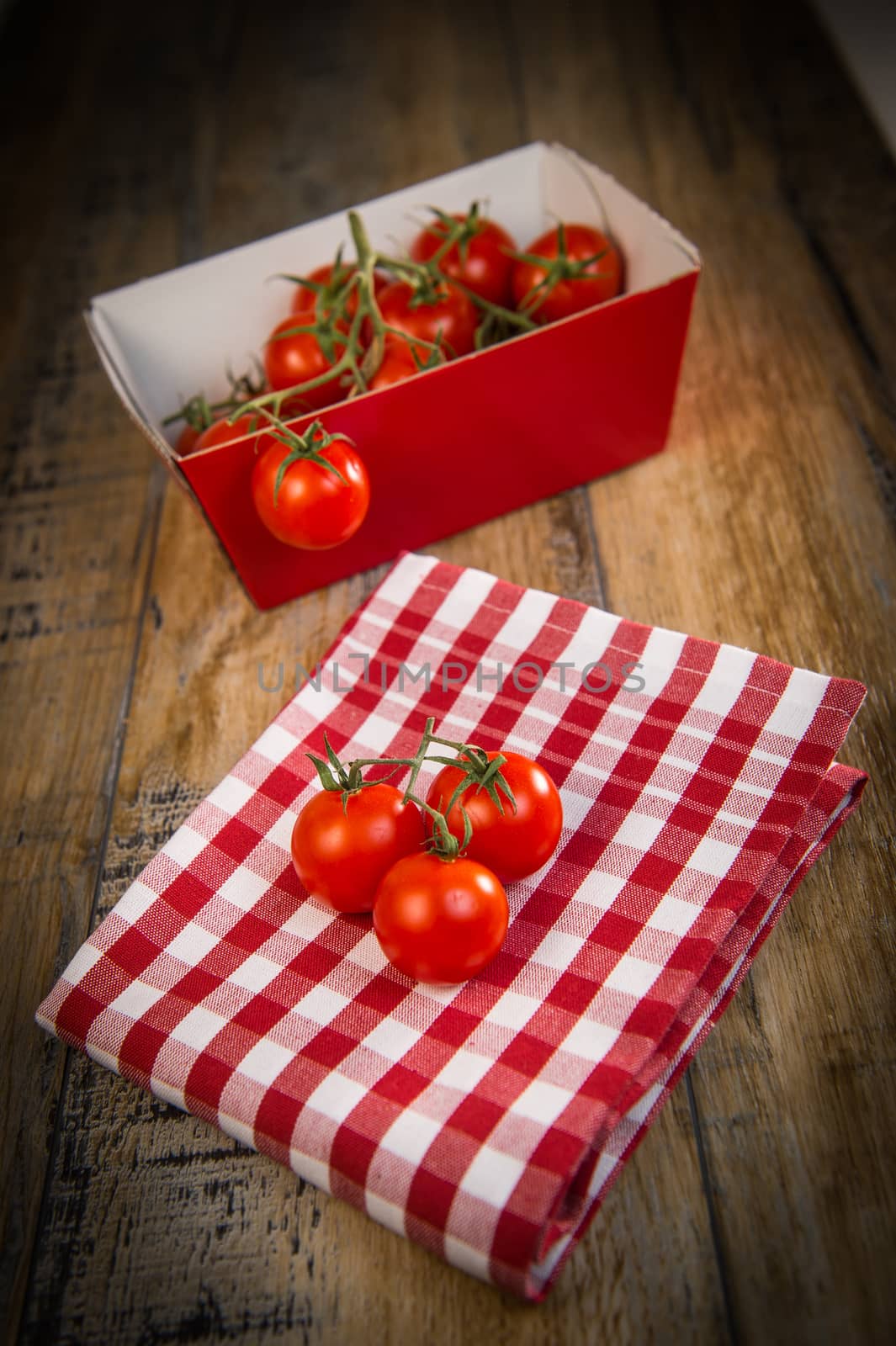 Fresh cherry tomatoes on travel and wooden background, France