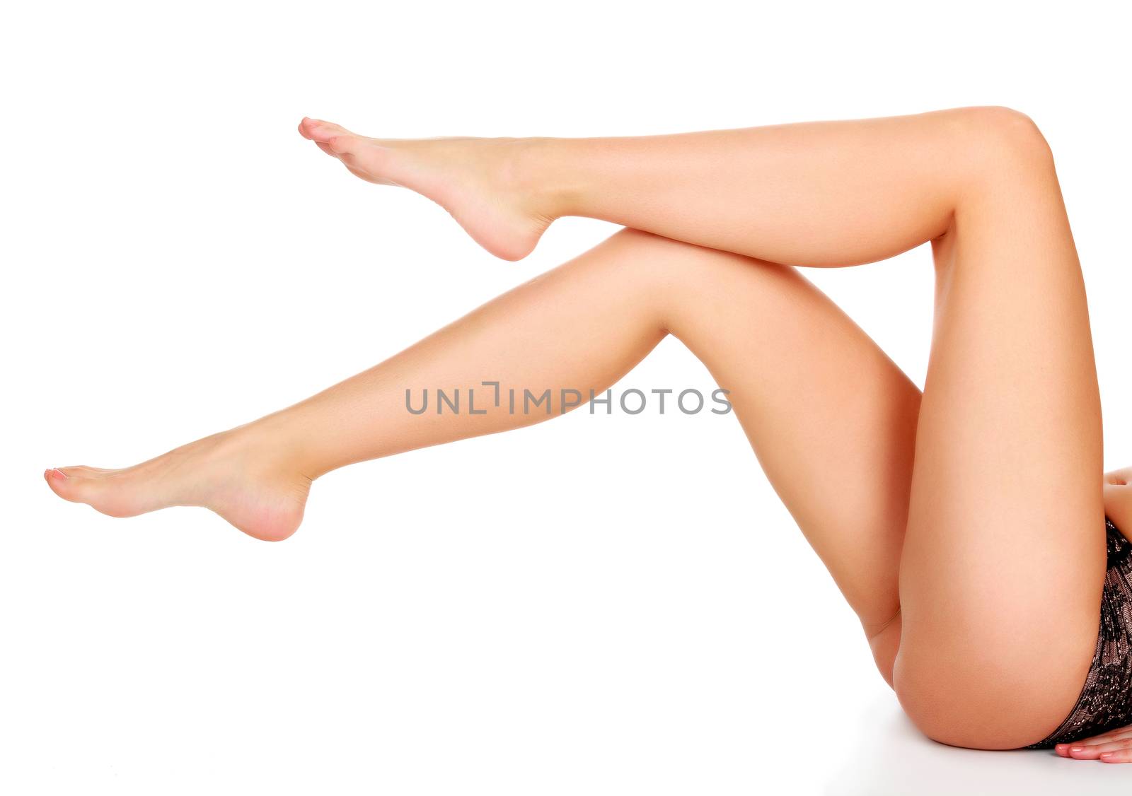 Closeup shot of beautiful long female legs isolated on white bac by Nobilior