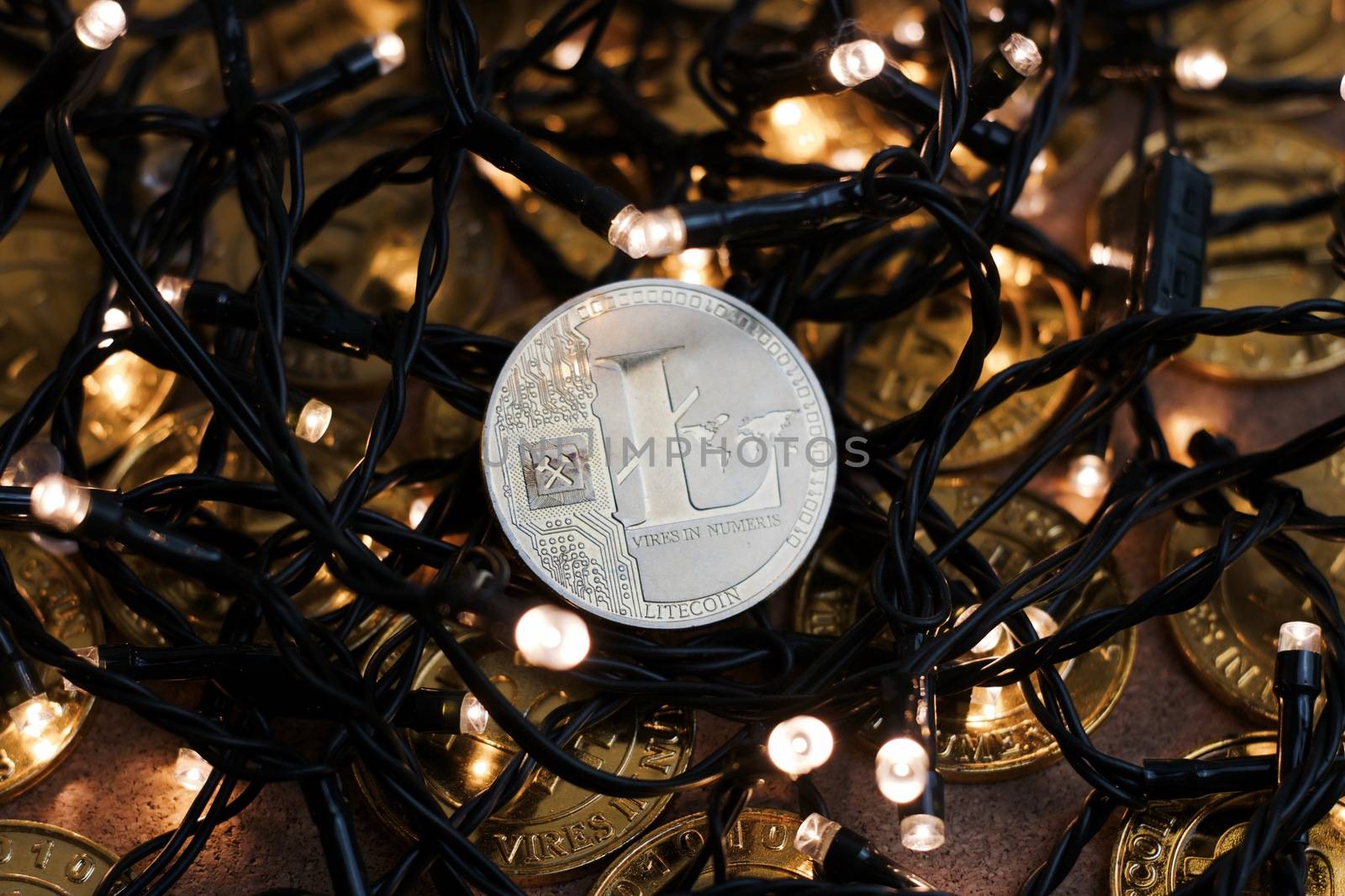 Digital currency physical metal Litecoin coin on the christmas lights concept.