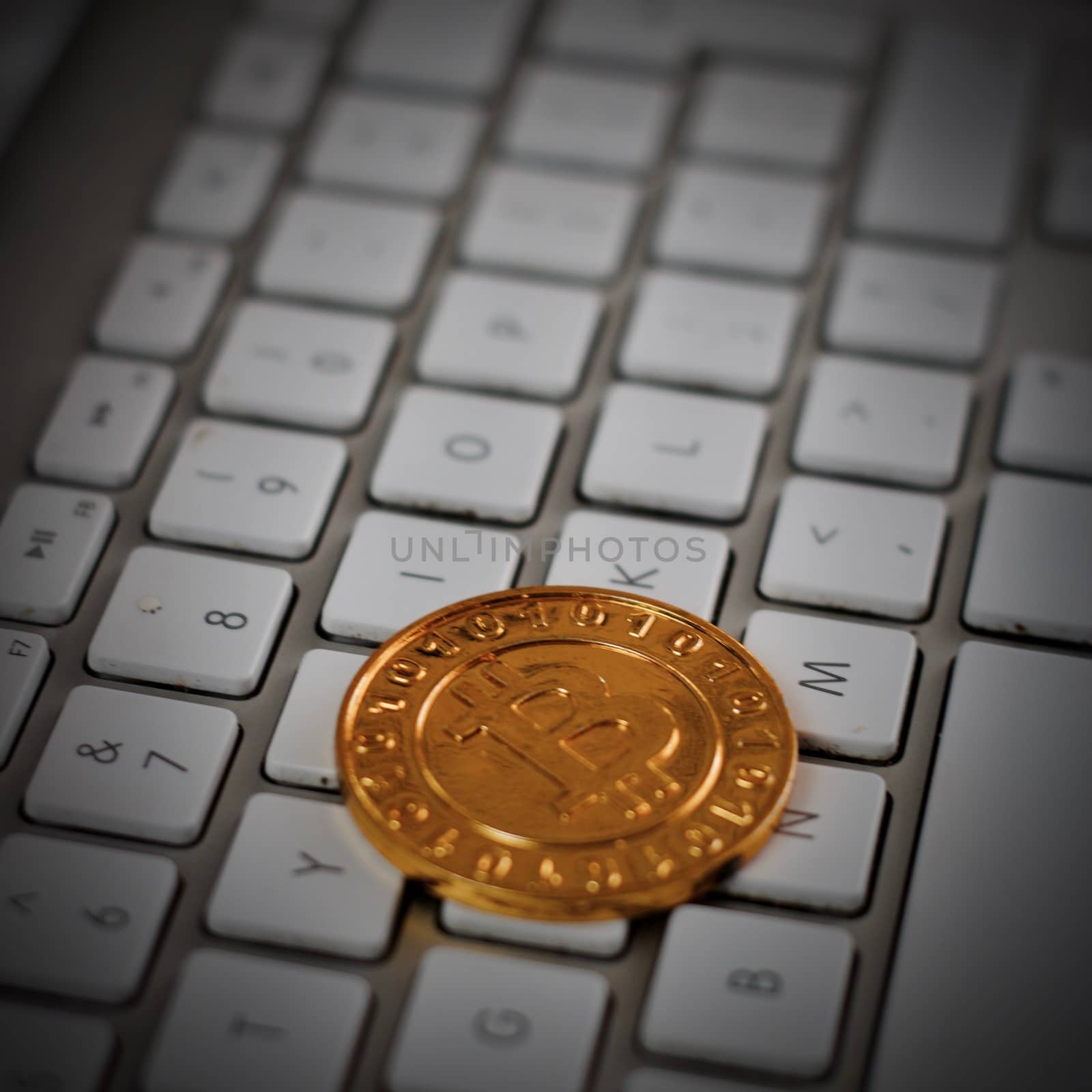 Cryptocurrency physical gold bitcoin coin on the white keyboard.