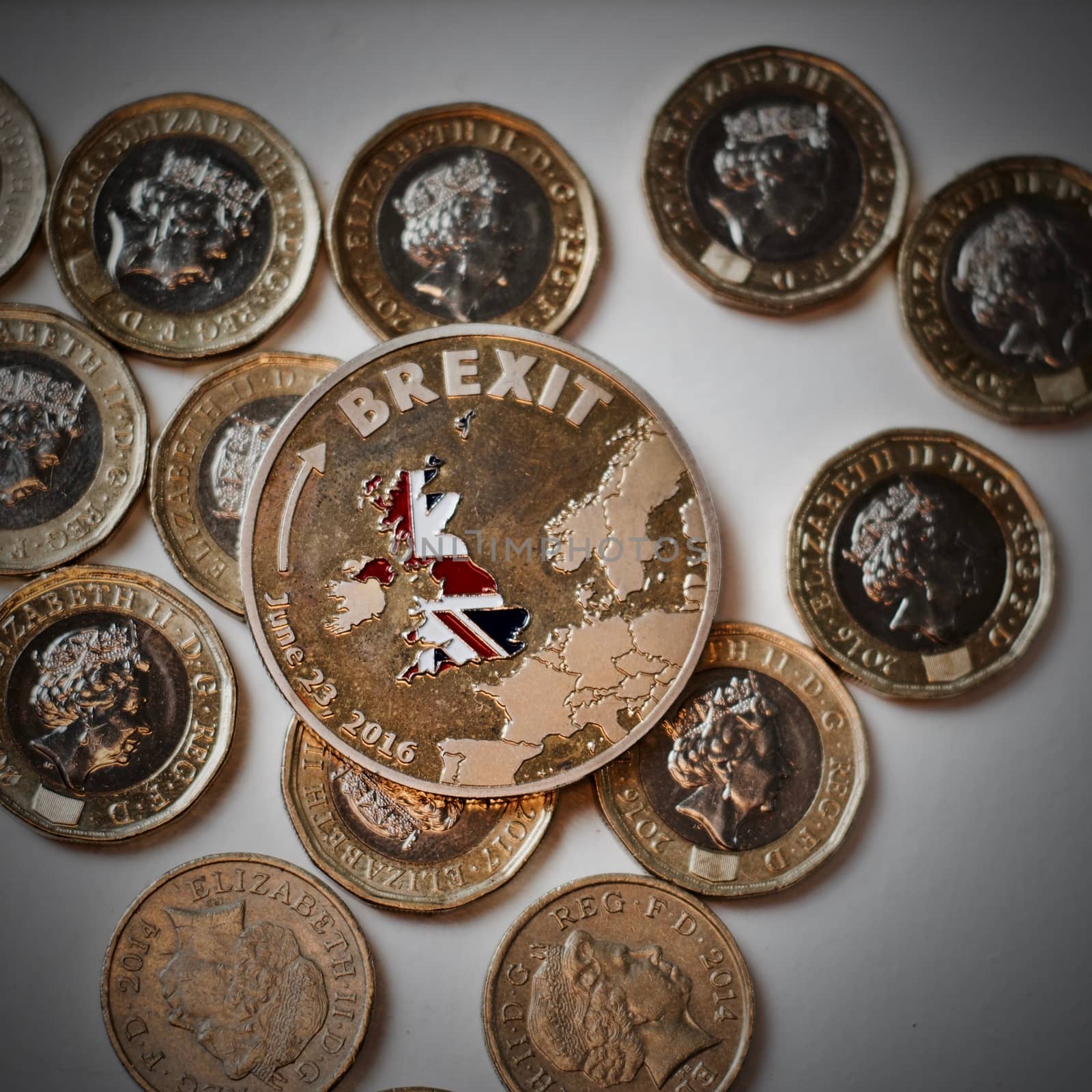 Europe leaving. Gold brexit coin with British map near keyboard and pound sterling.