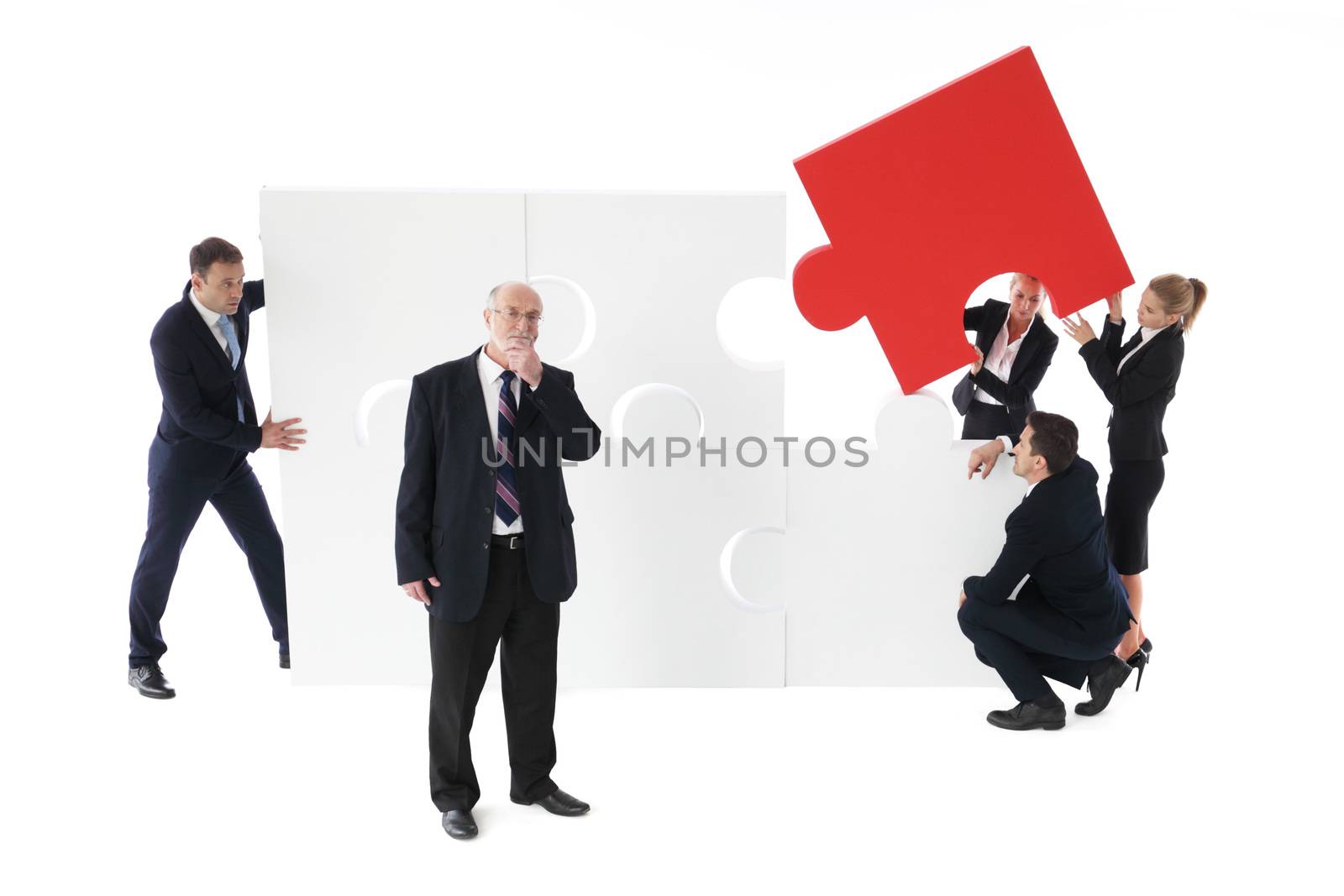 Business team assembling big puzzle by ALotOfPeople