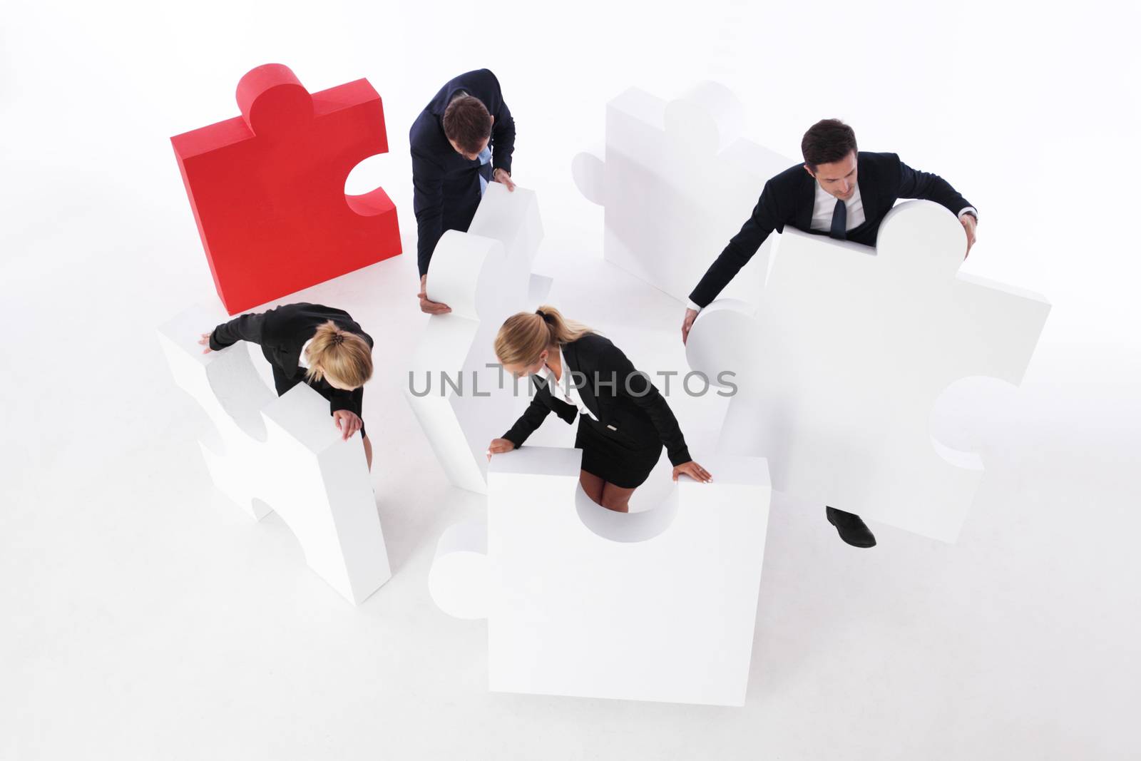 Business team assembling big puzzle on white background