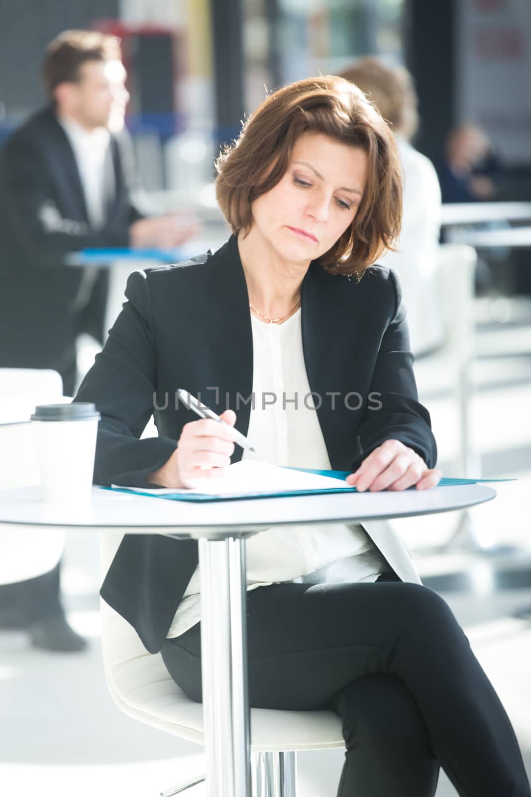 Business woman working with documents in cafe