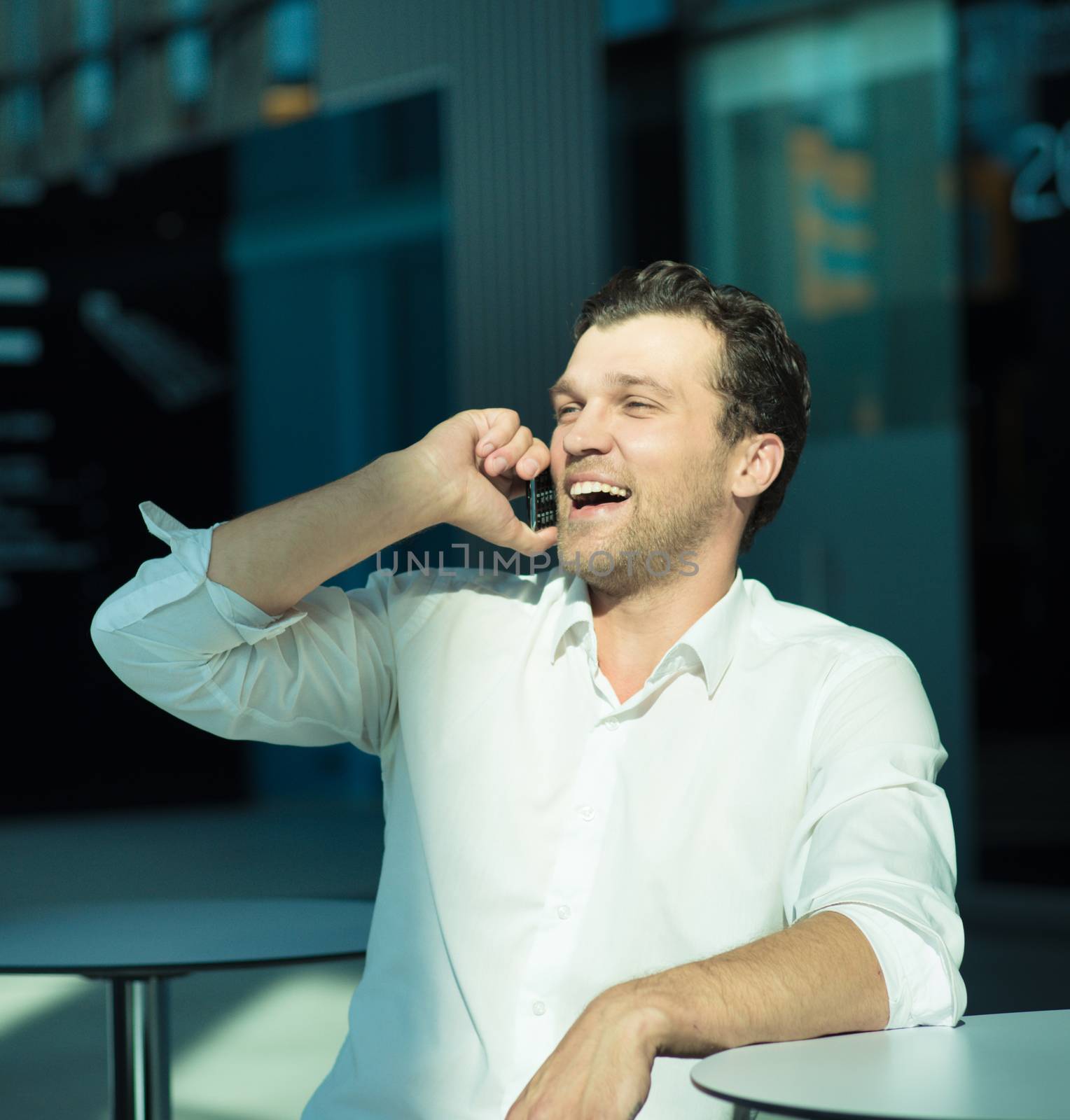 Portrait of a handsome businessman enjoy talking on mobile phone sitting in cafe