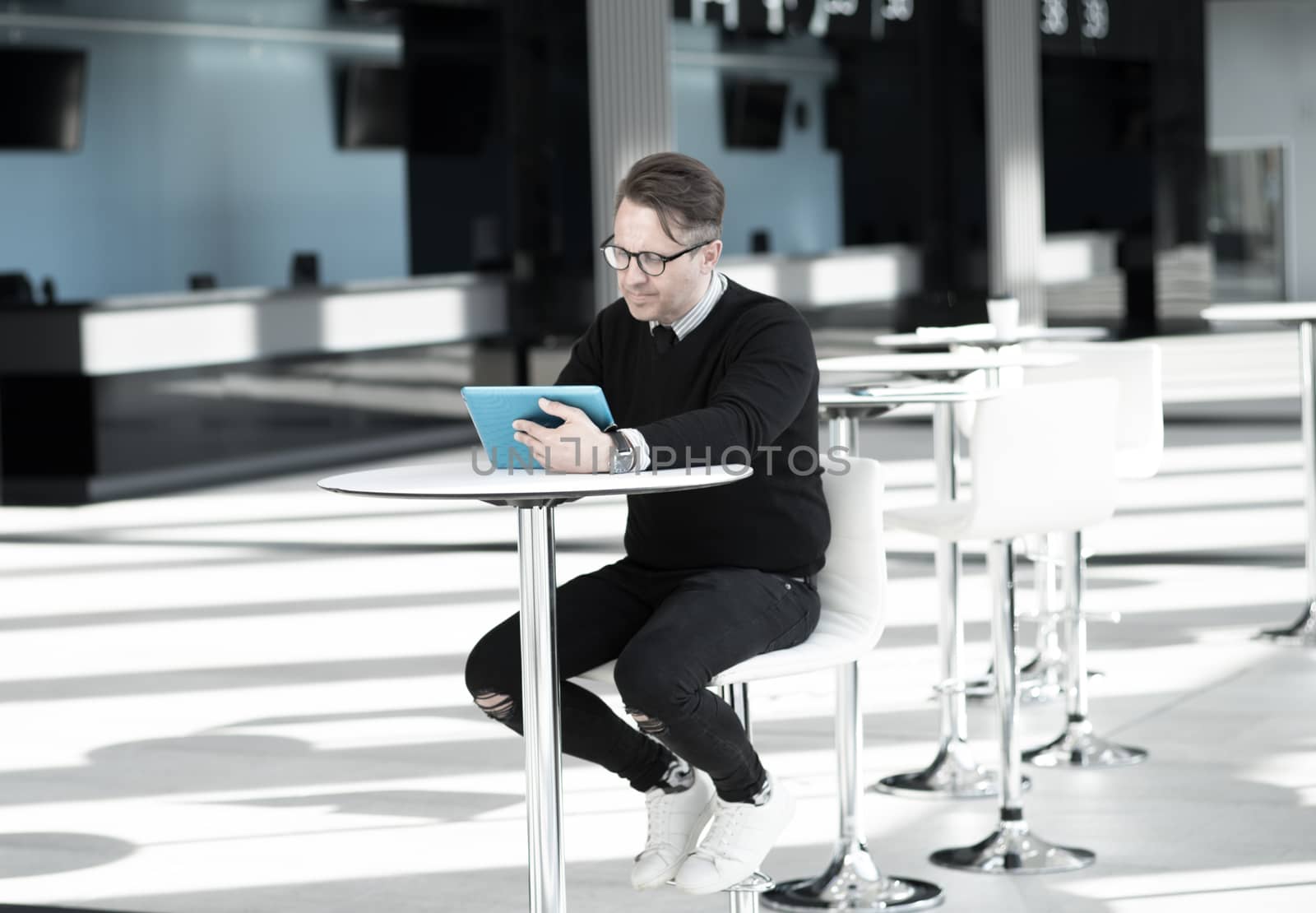 Man using tablet in cafe by ALotOfPeople