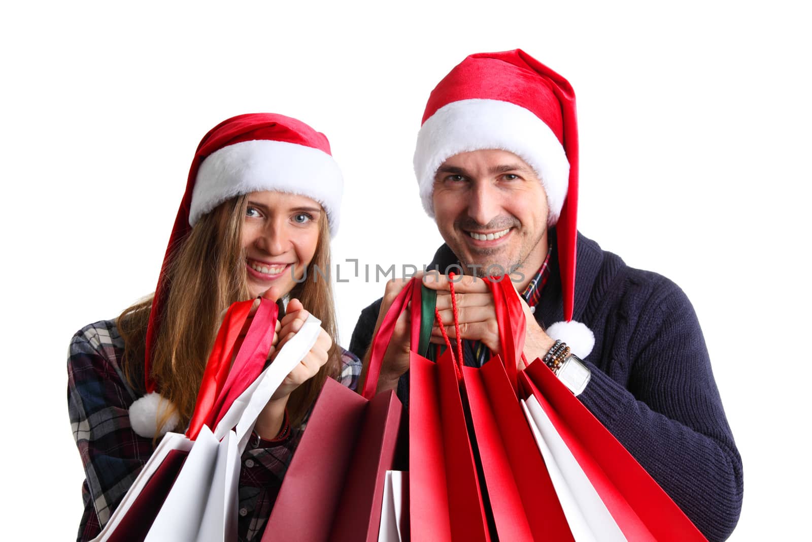 Happy beautiful couple holding many bags with christmas gifts isolated on white background