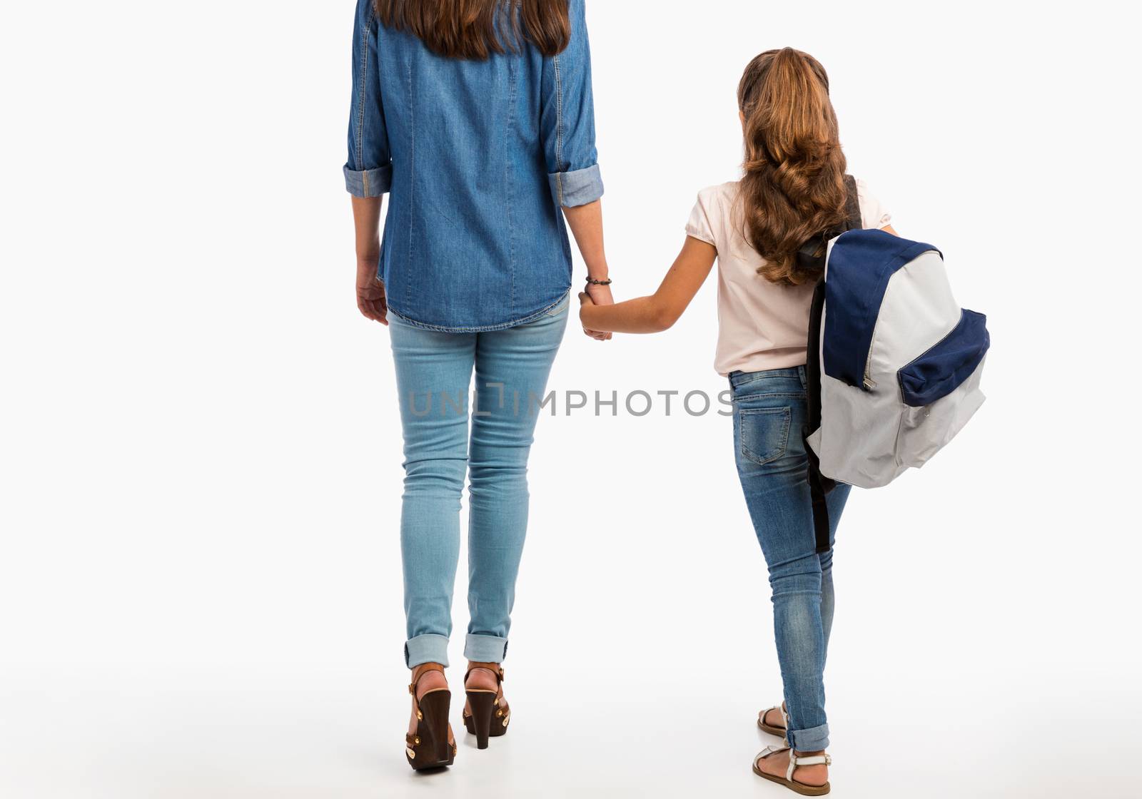 Mother and her little daughter walking together going to school