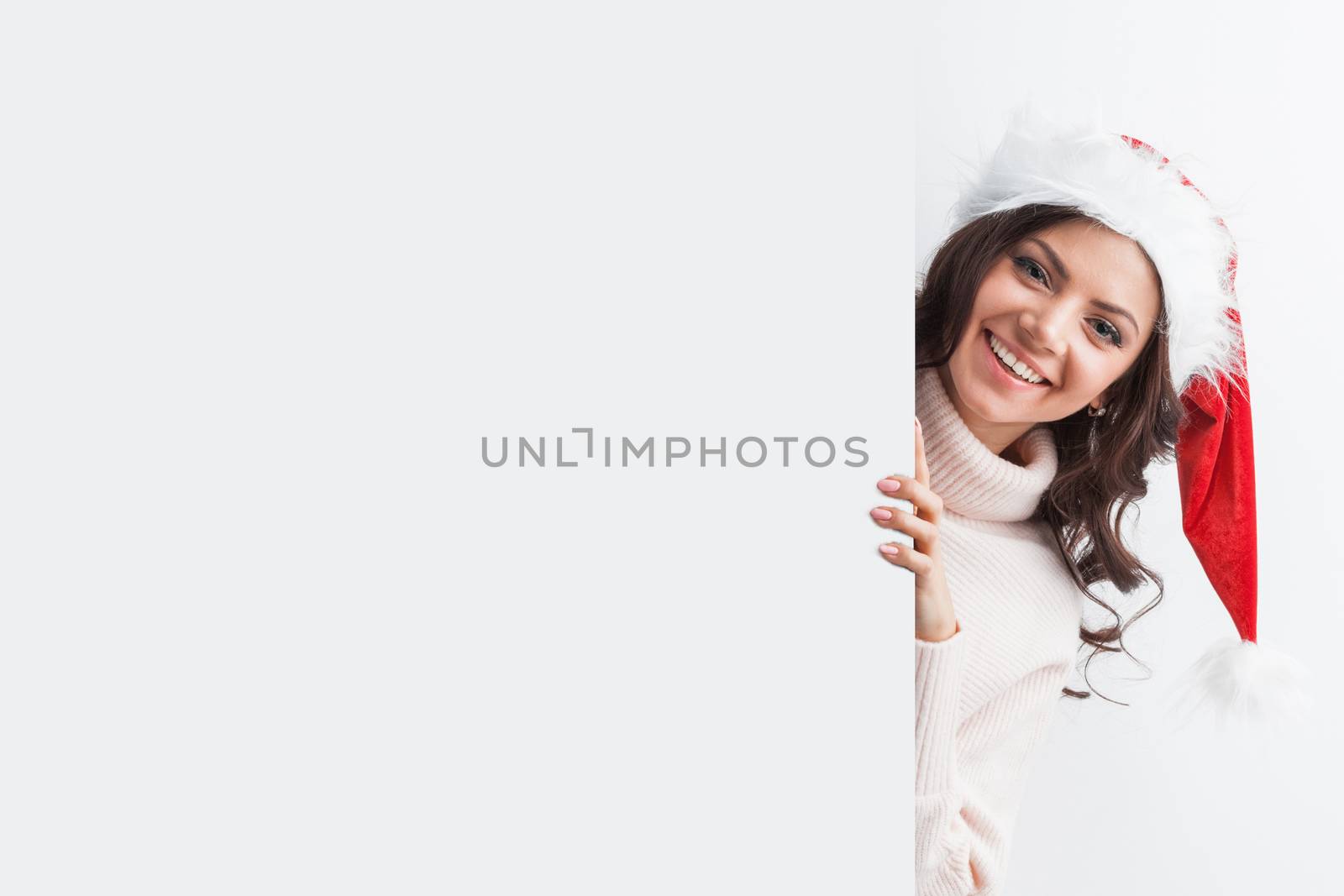 Woman in Santa hat with blank banner with white copyspace