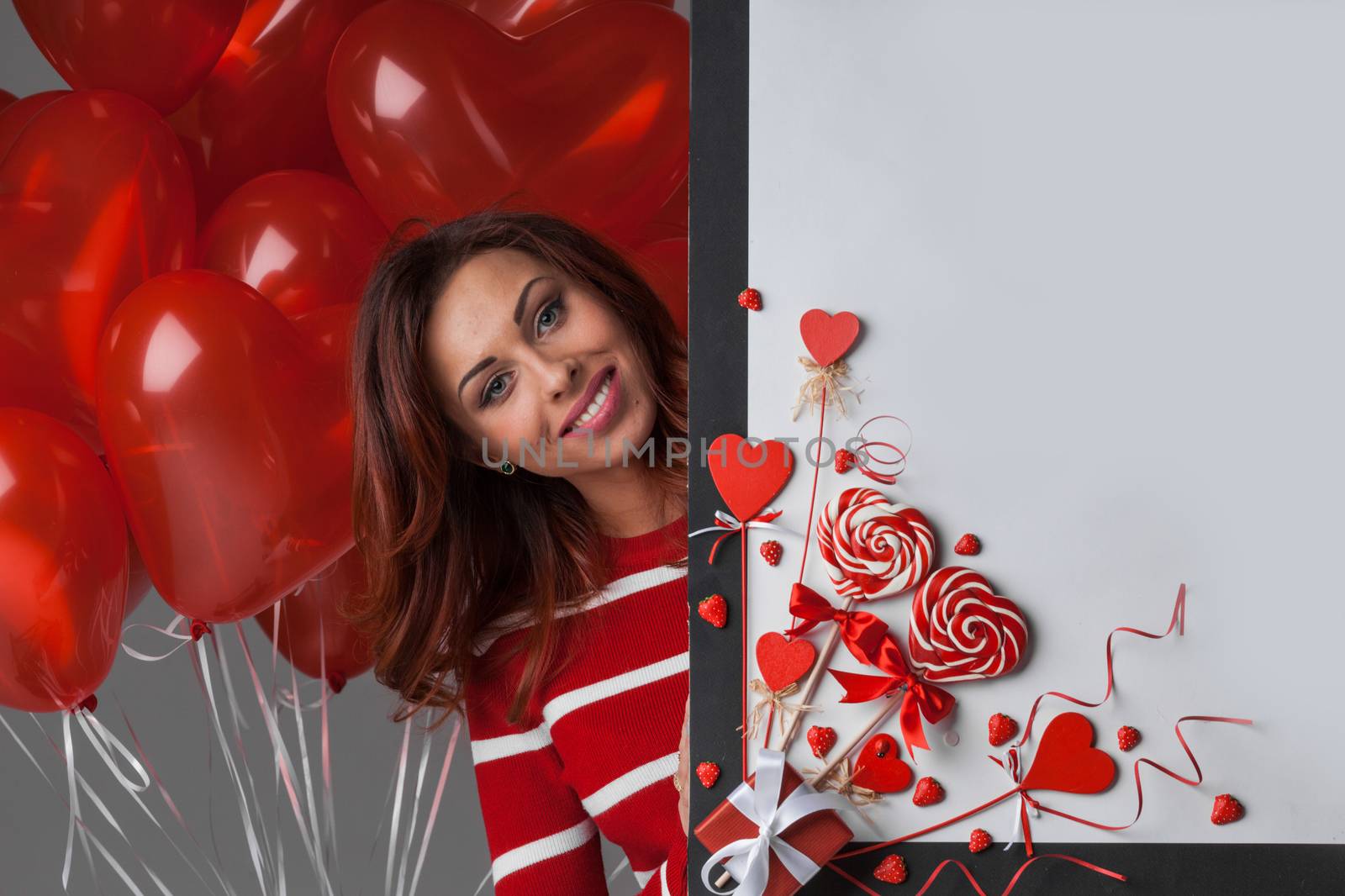 Woman with magic wand near Valentines day decoration and heart shaped lollipops isolated on white background
