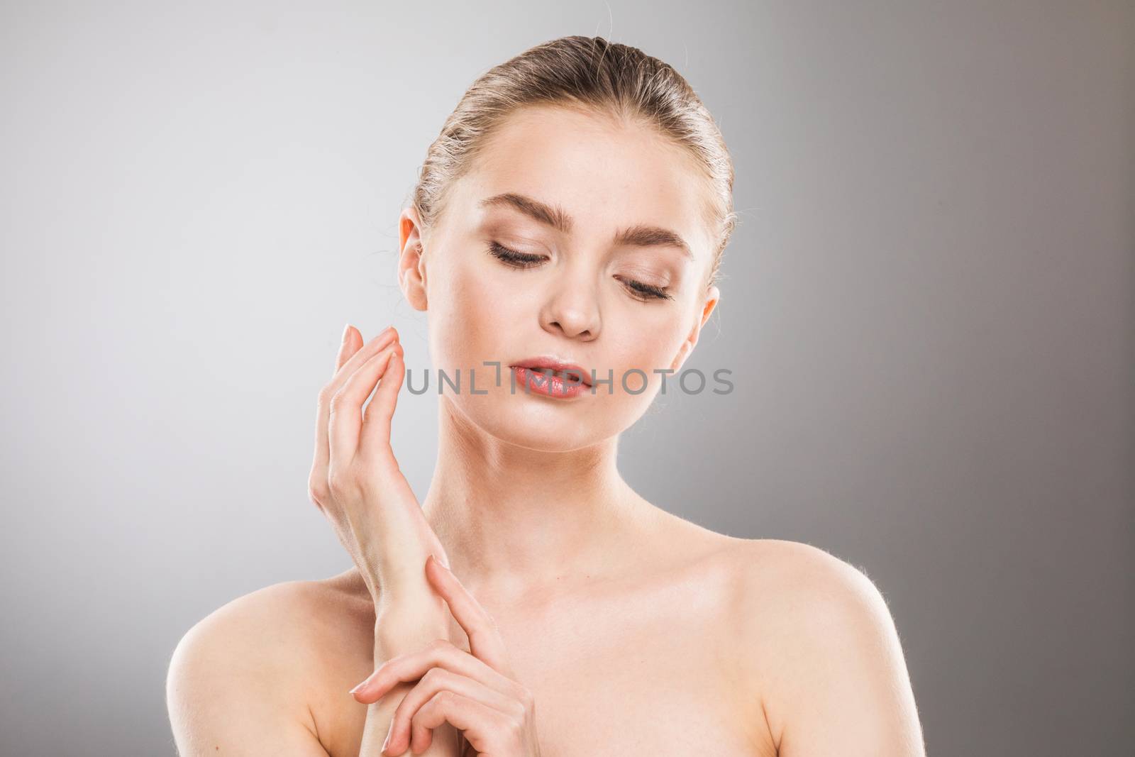 Beautiful young woman with clean fresh skin portrait on gray background