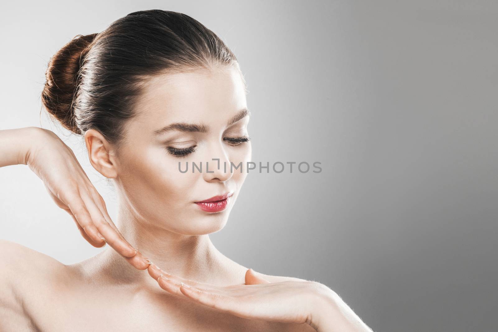 Beautiful young woman with clean fresh skin portrait on gray background