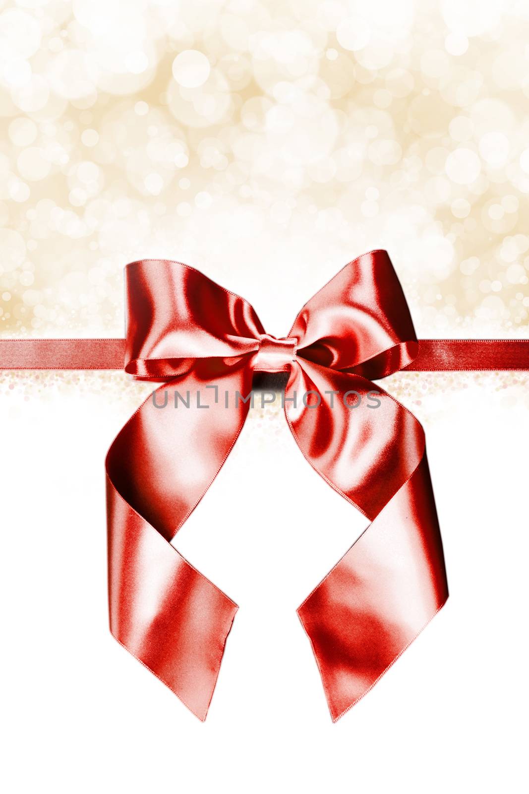 Red gift ribbon bow and golden bokeh isolated on white background