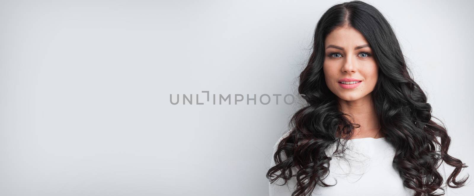 Beautiful brunette model with long curly black hair, studio shot