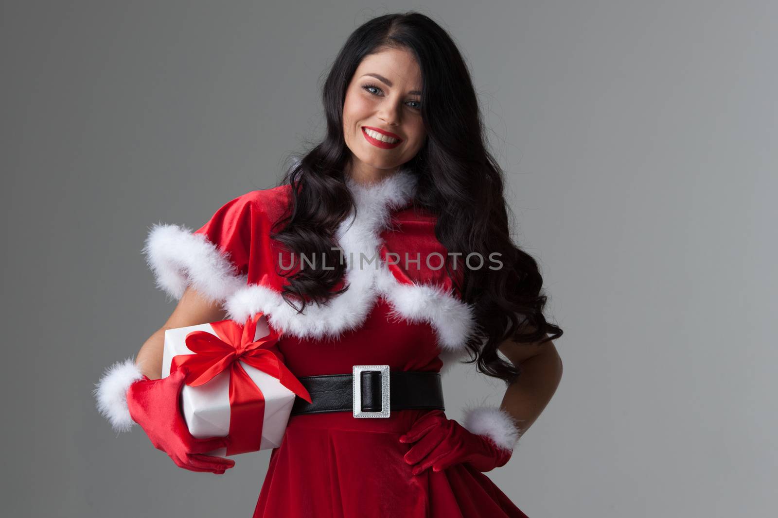 Woman in red Santa Claus outfit holding christmas gift box
