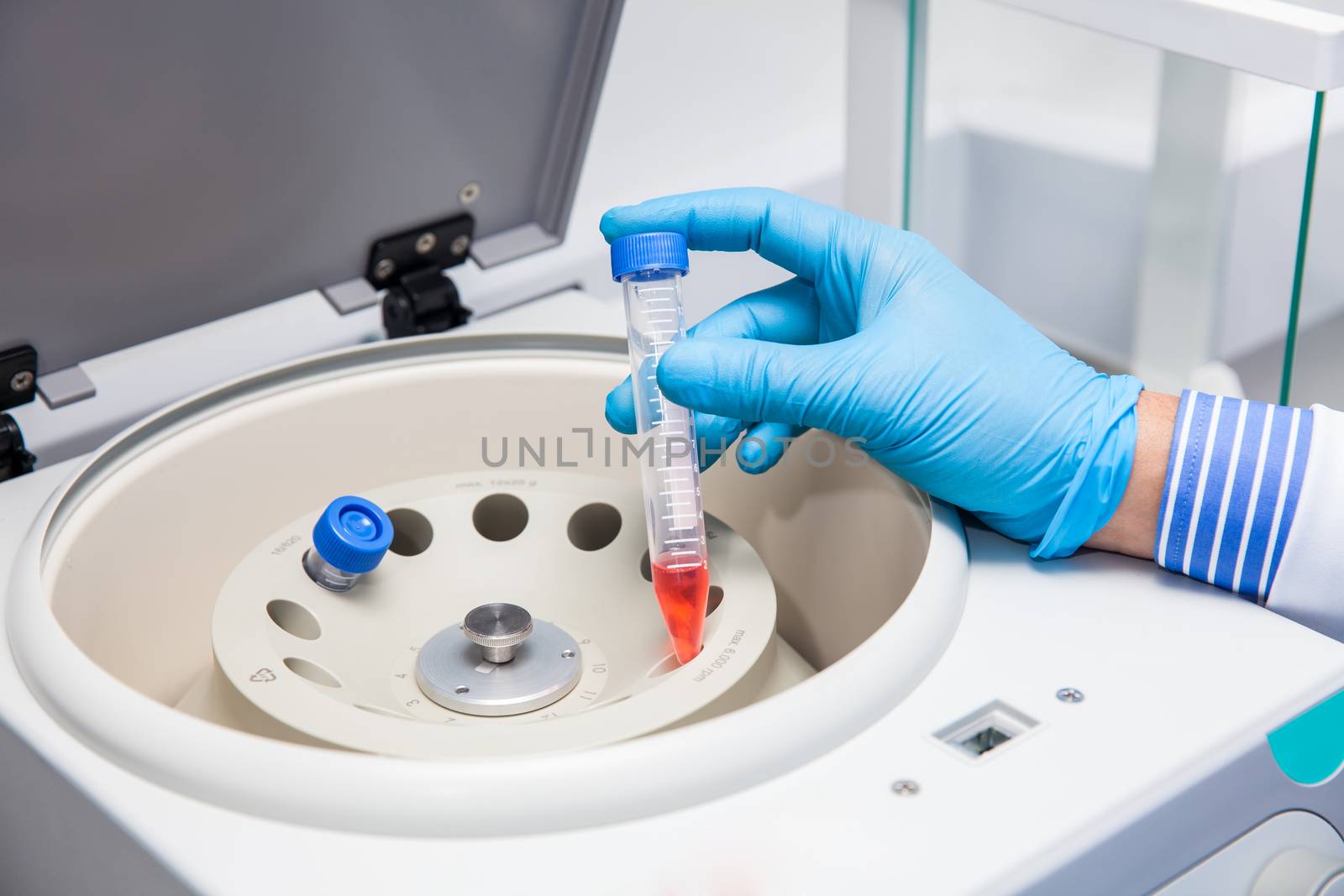 Scientist inserting a tube in a laboratory centrifuge