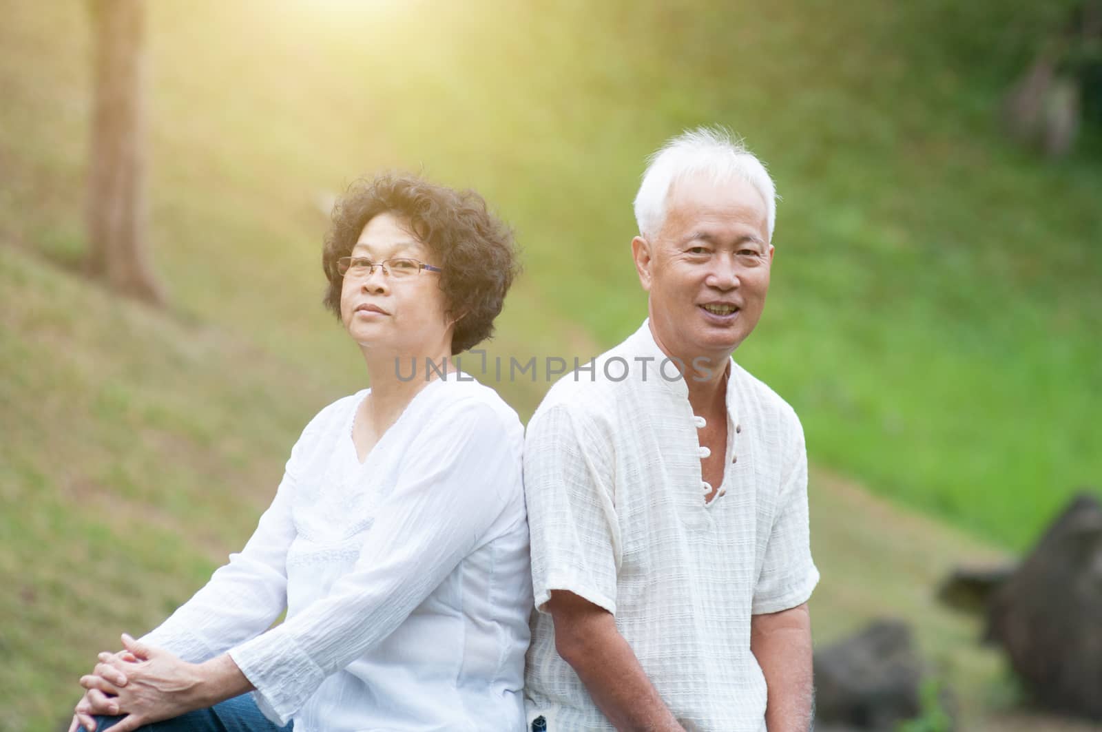 Happy Asian senior couple relaxing at outdoor park.