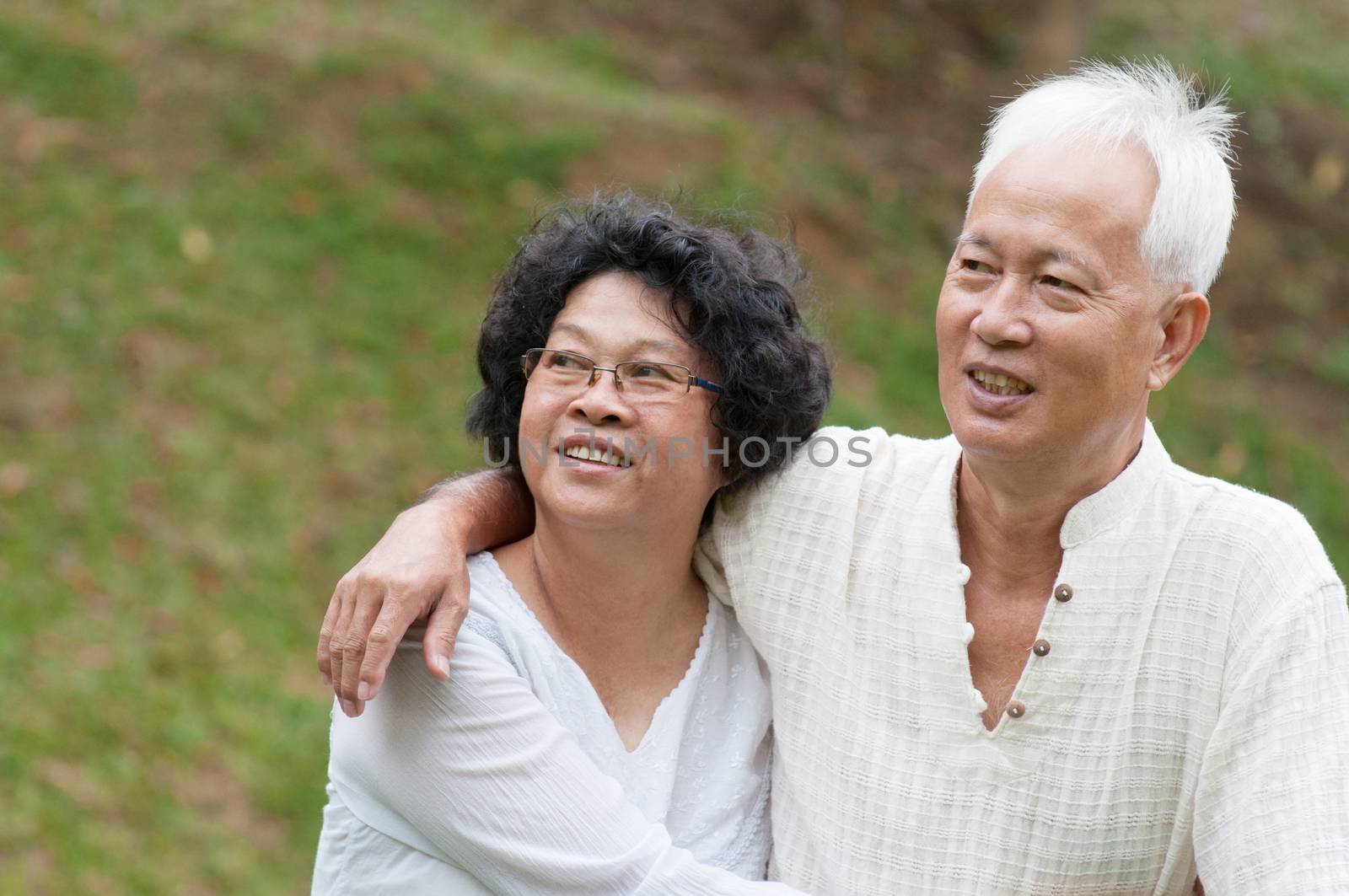 Beautiful happy Asian old people sitting in the summer park.