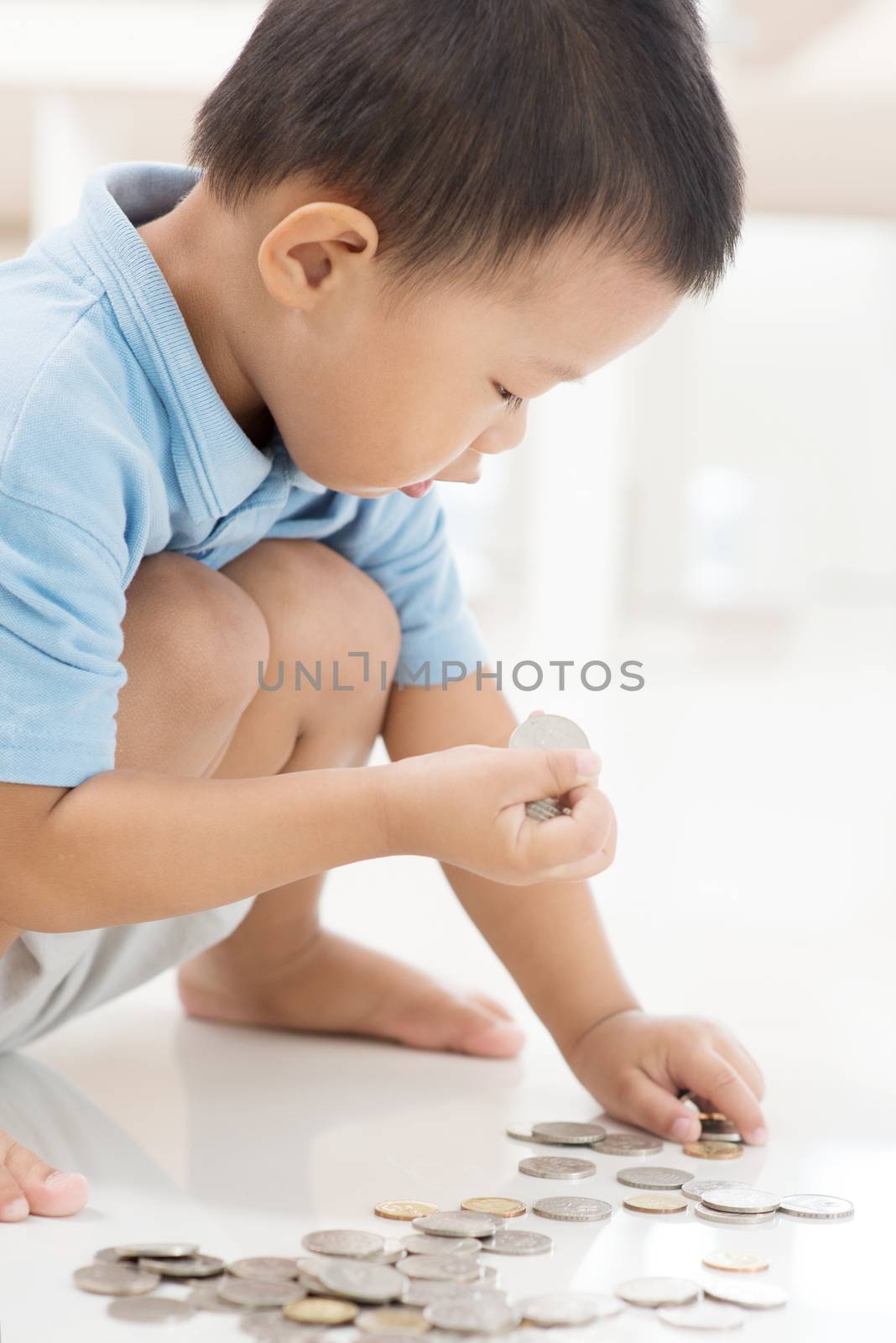 Asian kid saving money at home. Child education fund concept. 