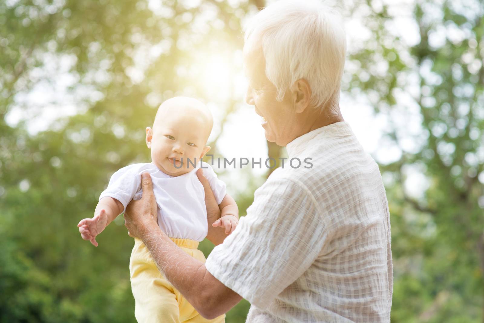 Grandparent and grandchild at outdoor park. by szefei