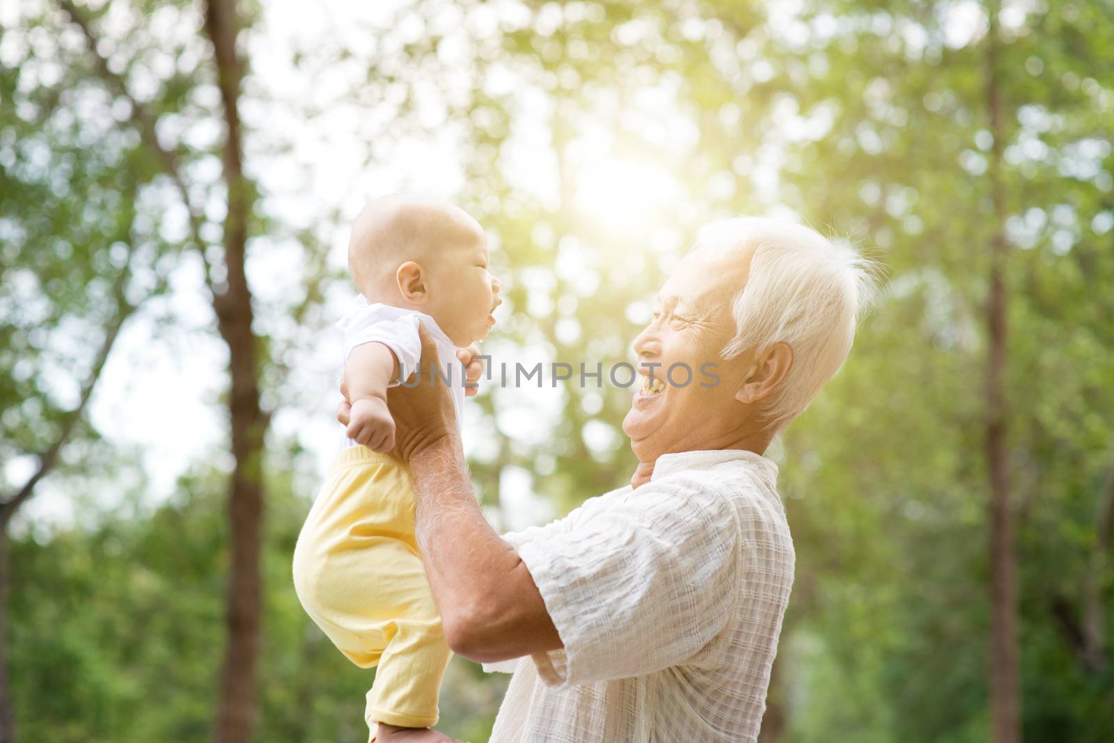 Baby grandson and grandfather having fun outdoors. Asian family, life insurance concept.