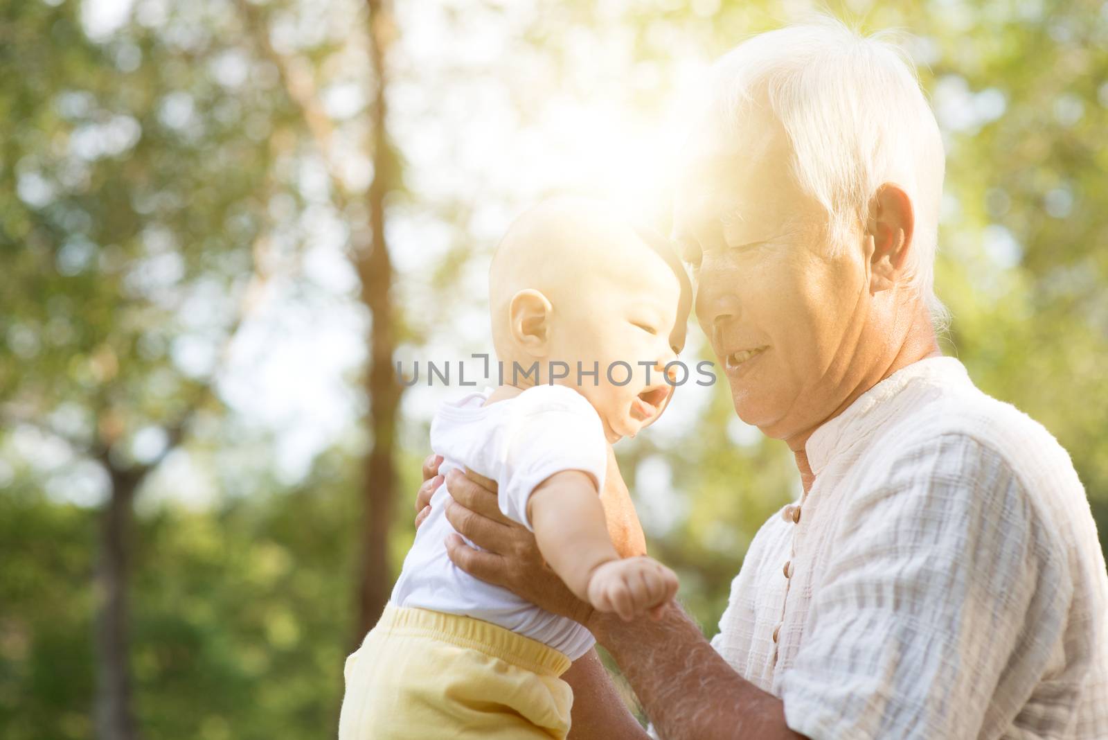 Grandfather with baby grandson at outdoor park, Asian family, life insurance concept.