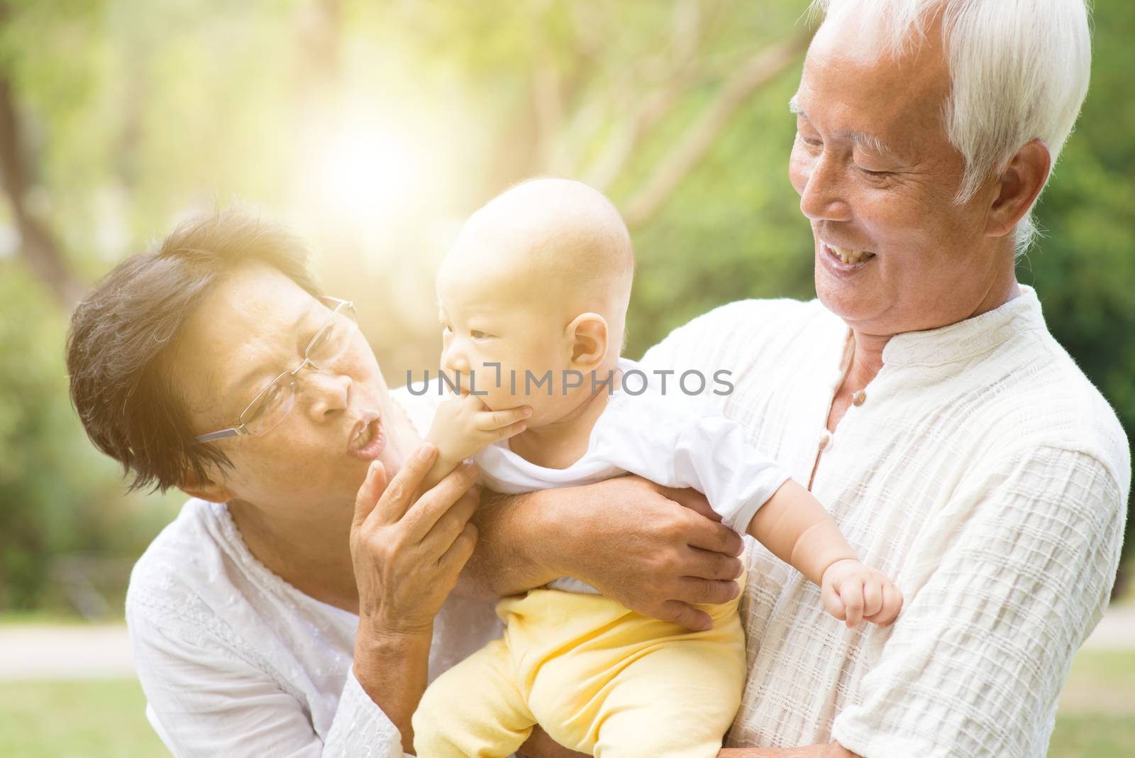 Grandparents and grandchild outdoors. by szefei