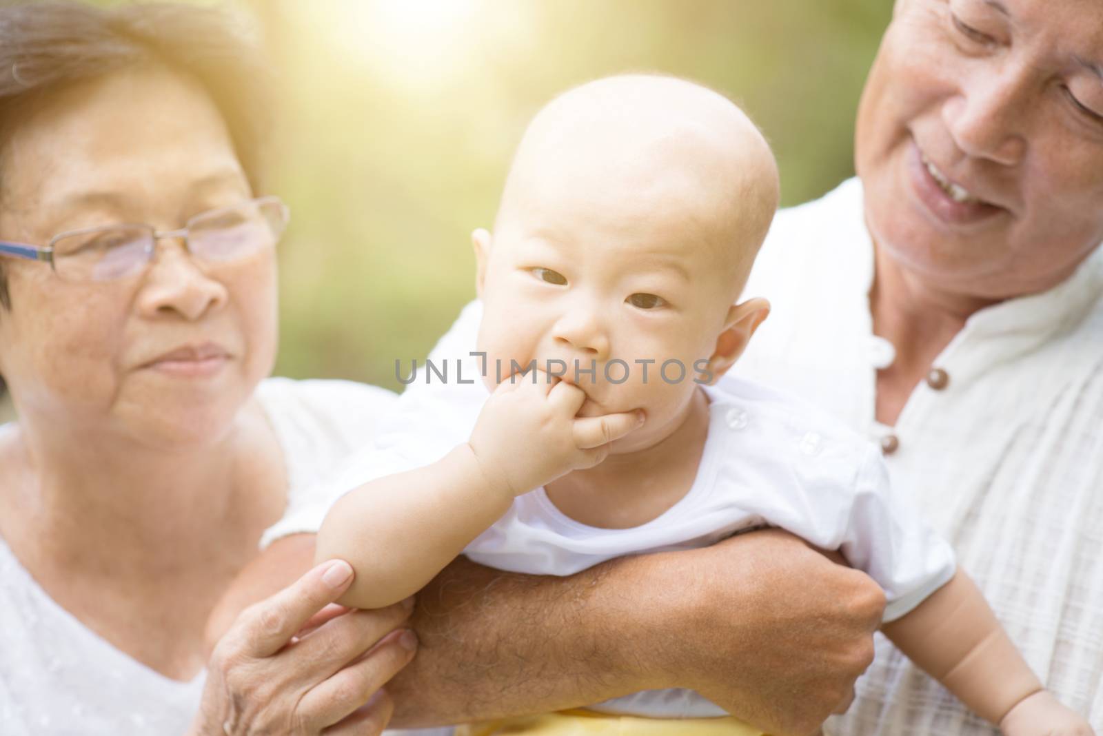Senior couple with baby grandchild, Asian grandparents family, life insurance concept.