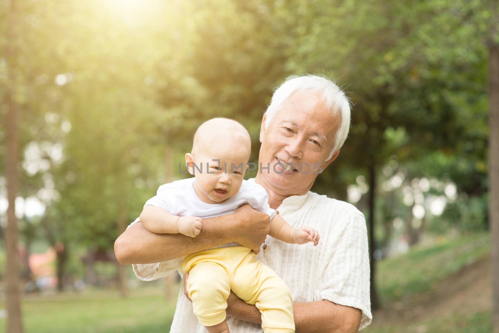 Grandfather with baby grandson at outdoor park, Asian family.