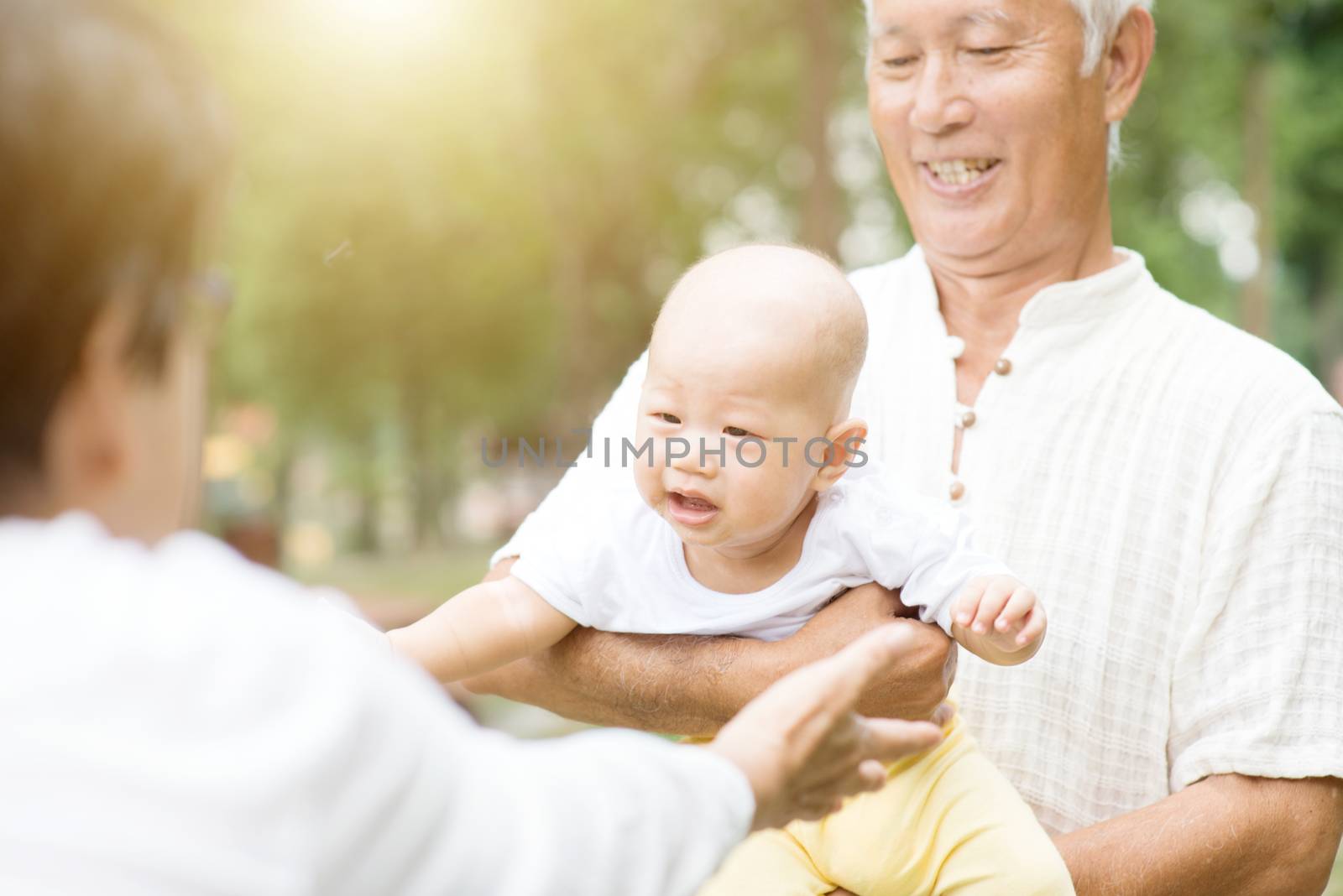 Happy grandparents playing with their grandchild at outdoor park, Asian family, life insurance concept.