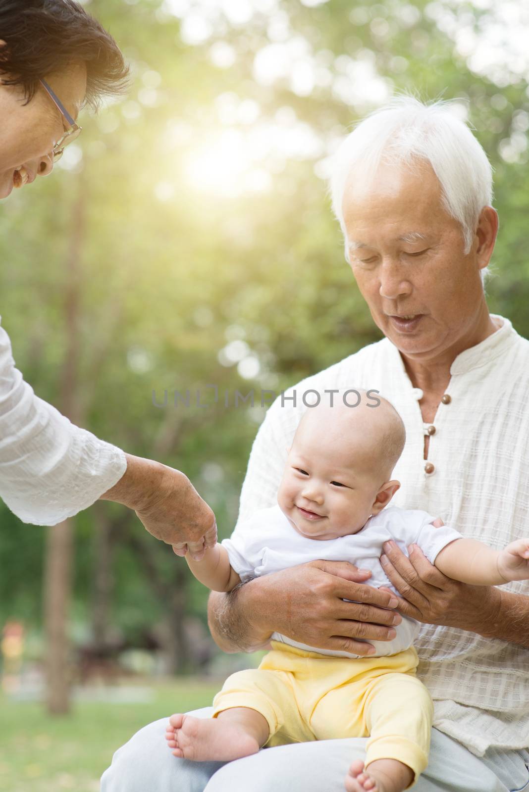 Grandparents and grandson having fun outdoors. by szefei