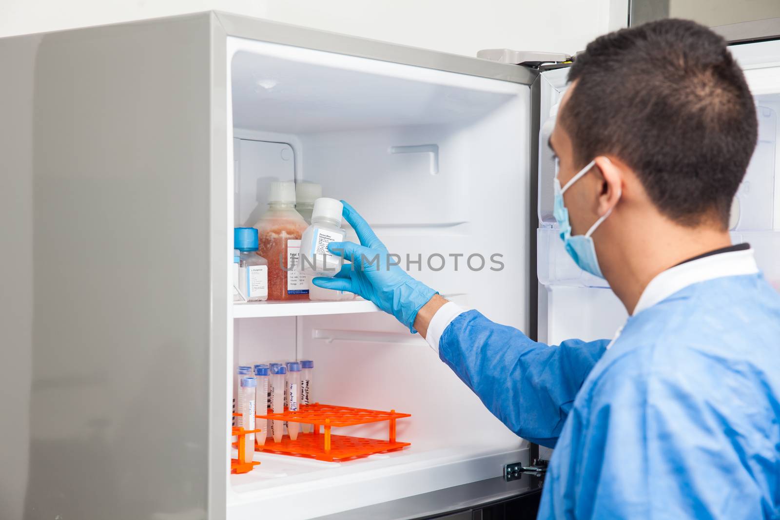 Young male scientist and laboratory freezer