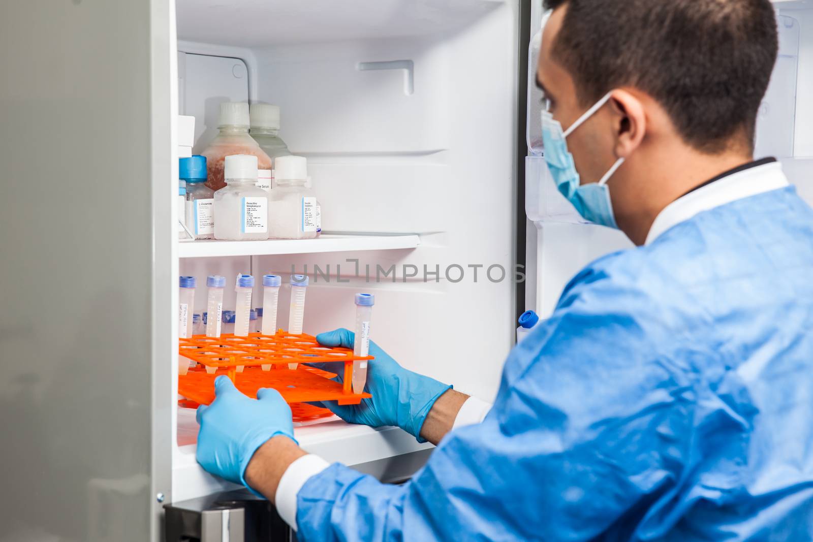 Young male scientist and laboratory freezer