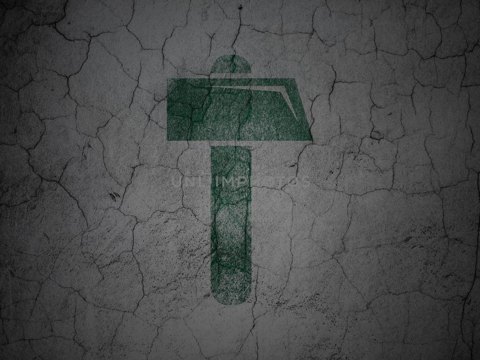 Constructing concept: Green Hammer on grunge textured concrete wall background